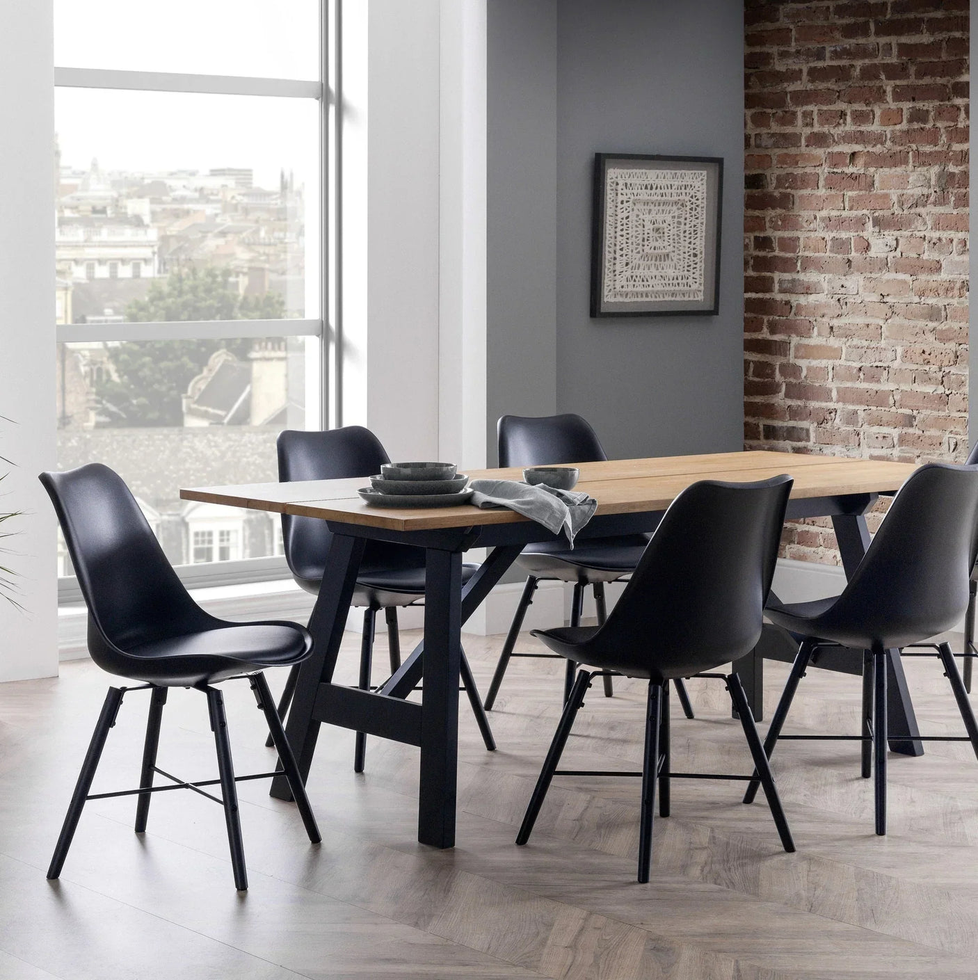 Black dining chairs with curved seats around a wooden dining table in a modern dining room
