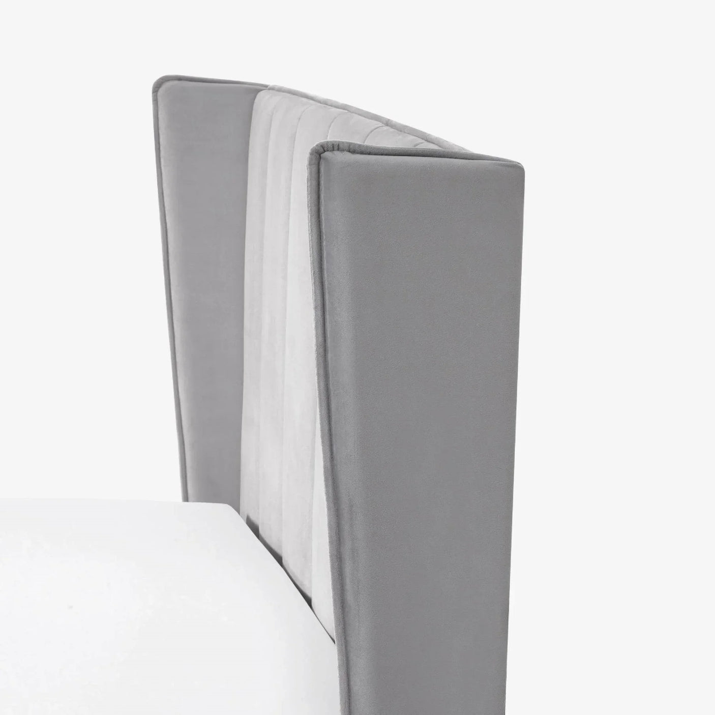 Close-up of grey velvet bed headboard with panelled vertical stitching