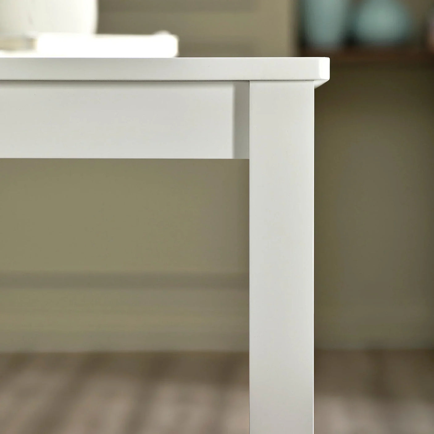 White wooden dining table corner with clean lines and matte finish