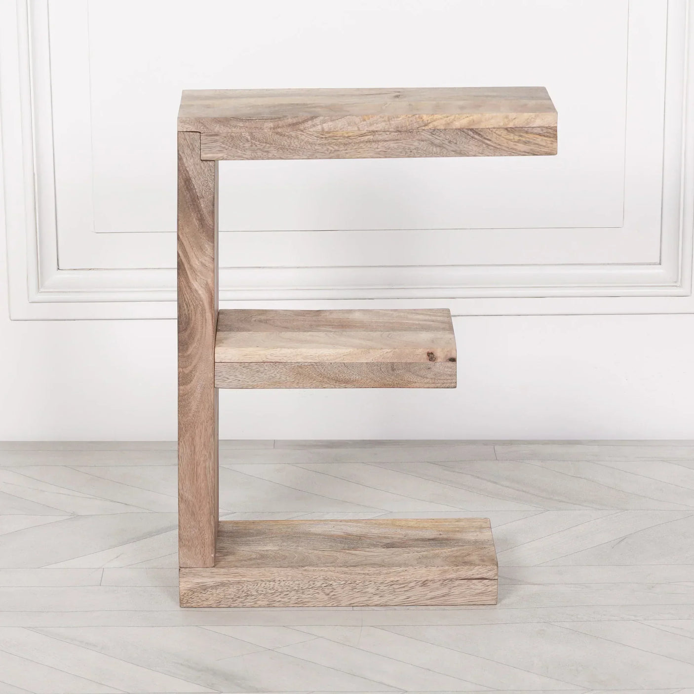 Solid wood side table with C-shaped design and two shelves on light wood floor