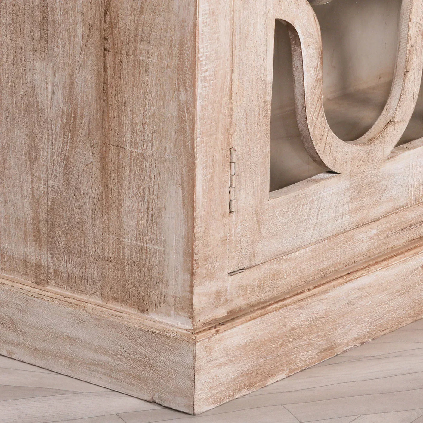 Distressed wood cabinet corner with carved door and glass panel detail