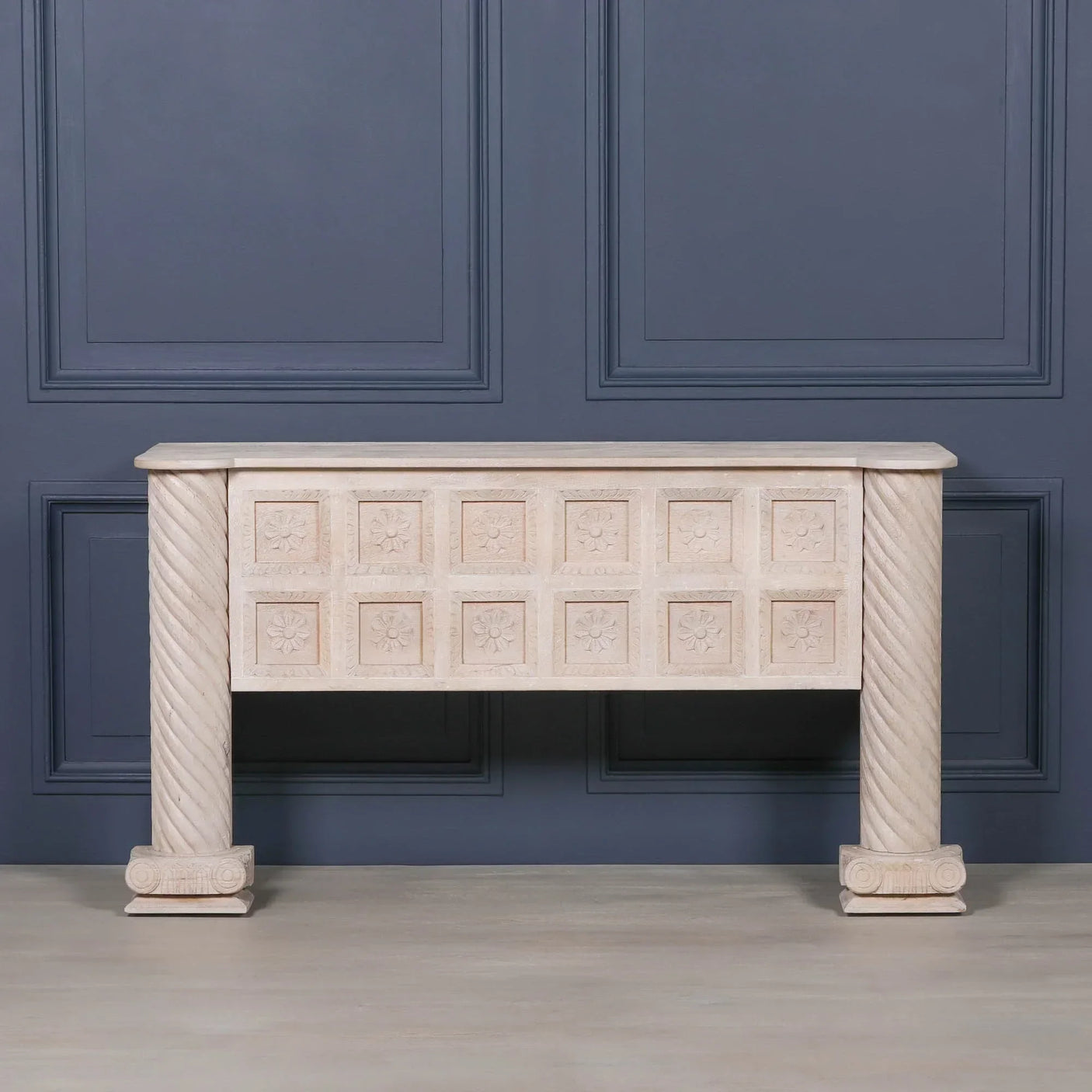 Carved stone fireplace surround with floral panel details and twisted column legs