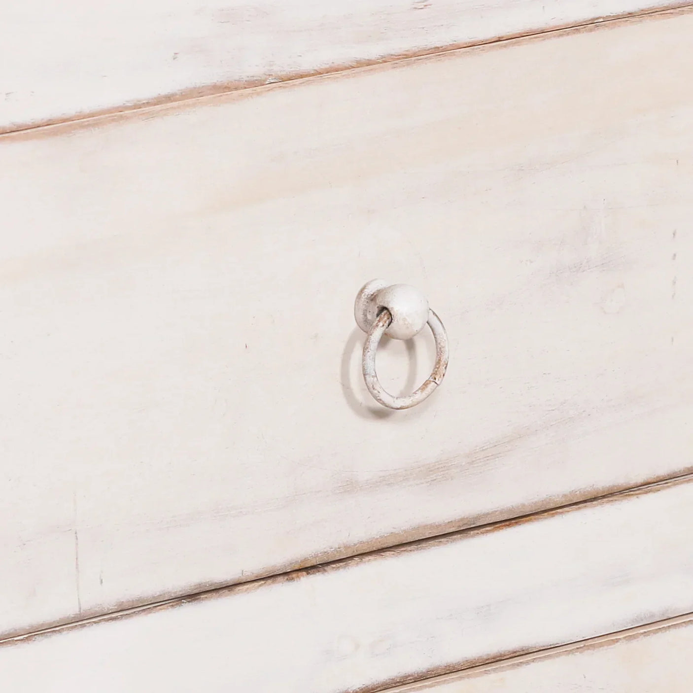 Distressed white wooden drawer with metal ring handle detail