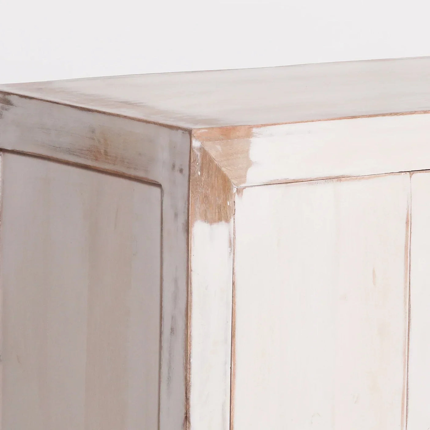 Distressed wood cabinet corner with whitewashed finish and panel detail