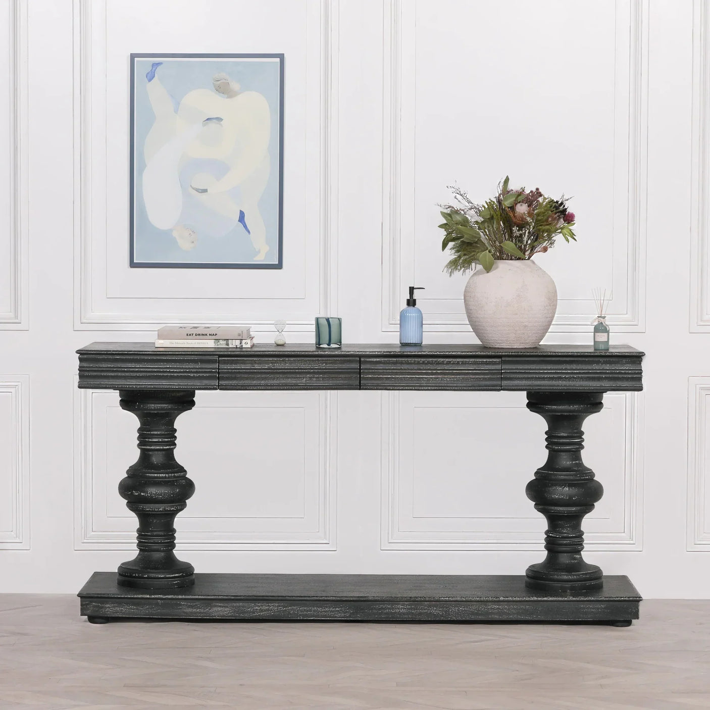Black wooden console table with turned legs and decorative vase in modern hallway