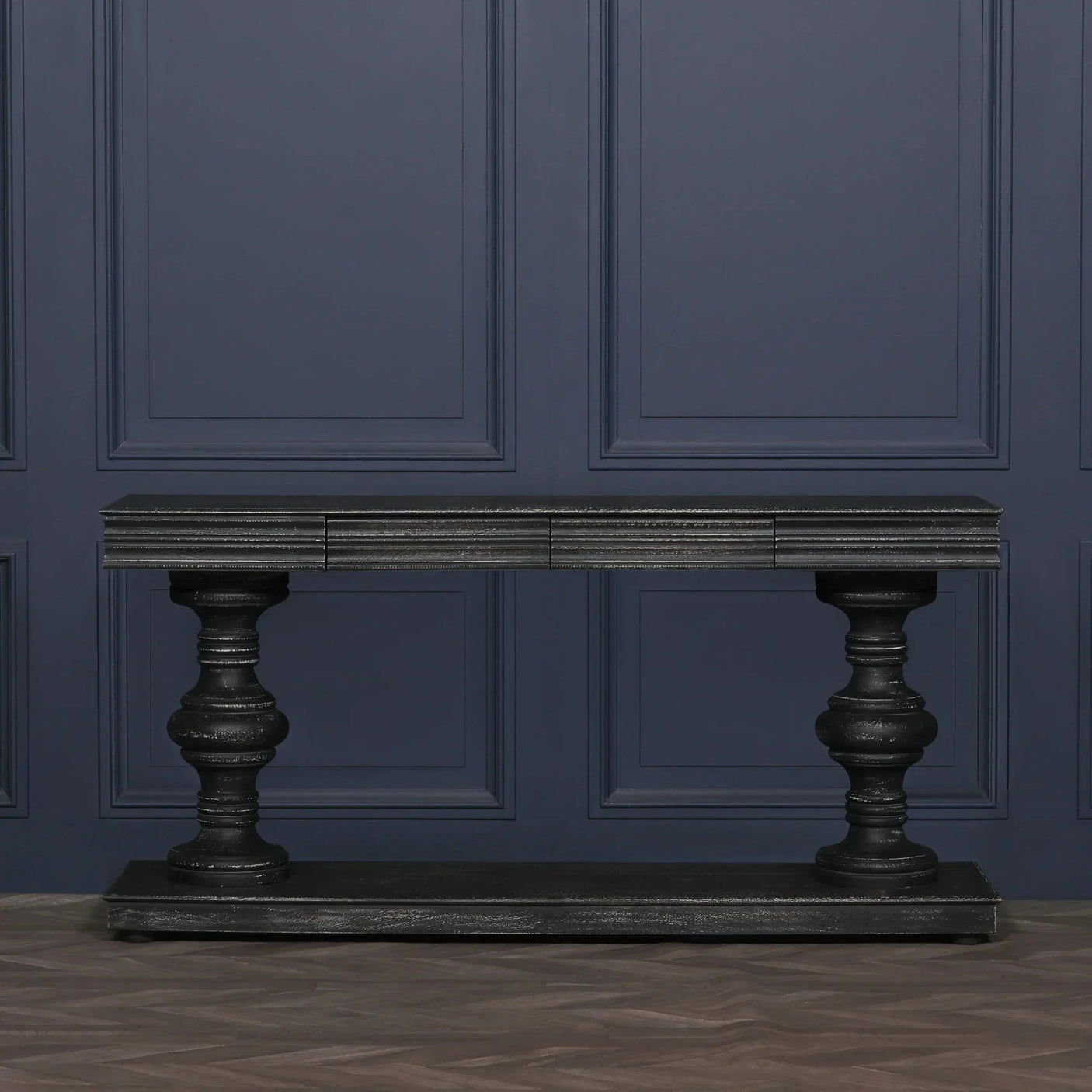 Black wooden console table with turned legs against blue panelled wall