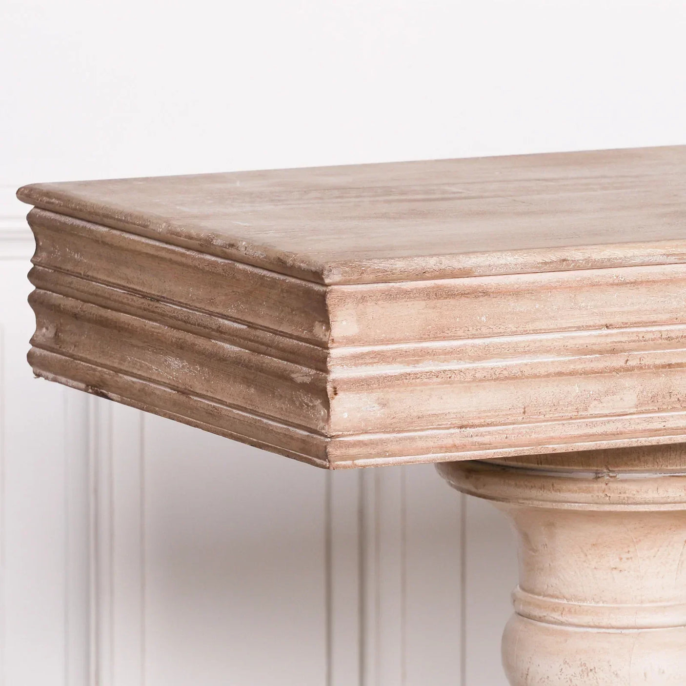 Oak dining table with square edge and carved pedestal base, light wood finish, closeup view