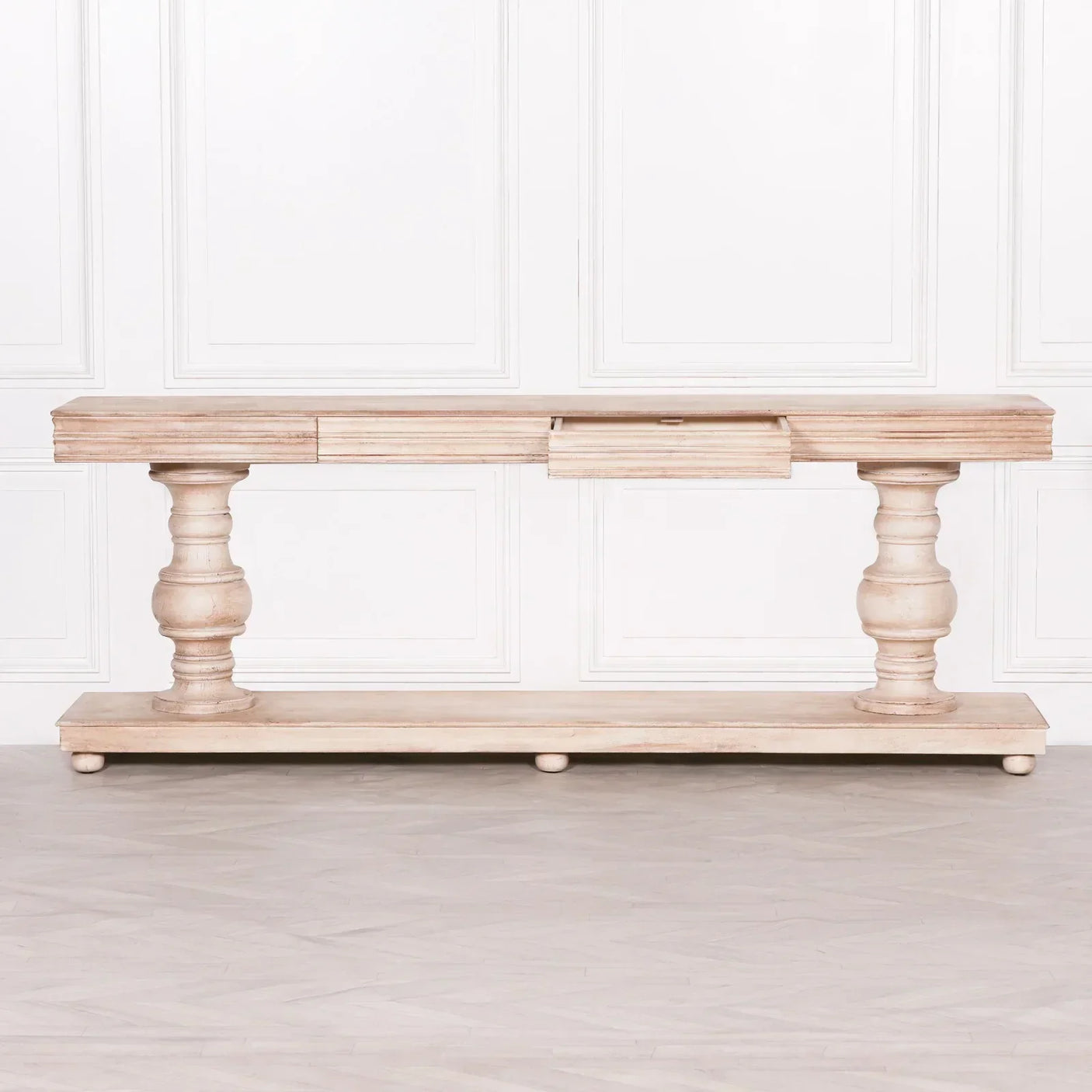 Rustic wood console table with turned legs and lower shelf against white panelled wall