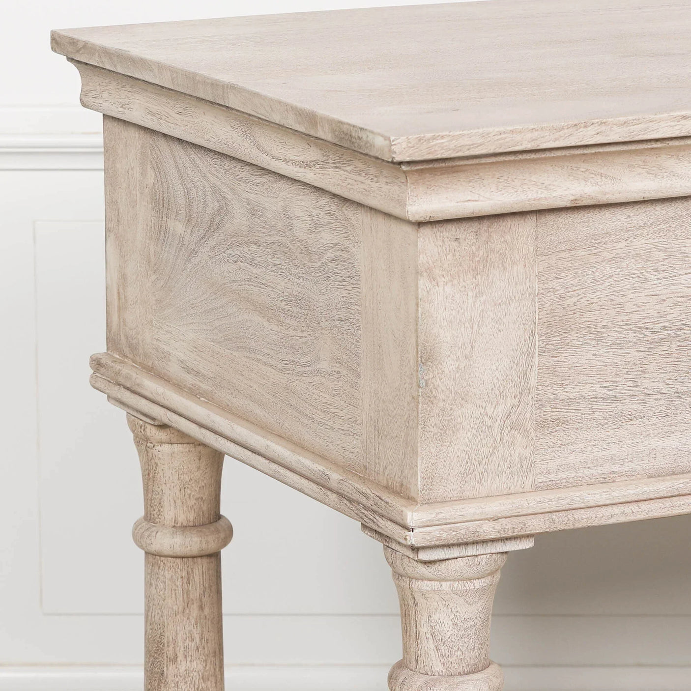 Light wood side table with carved legs and smooth grain finish, close corner detail view