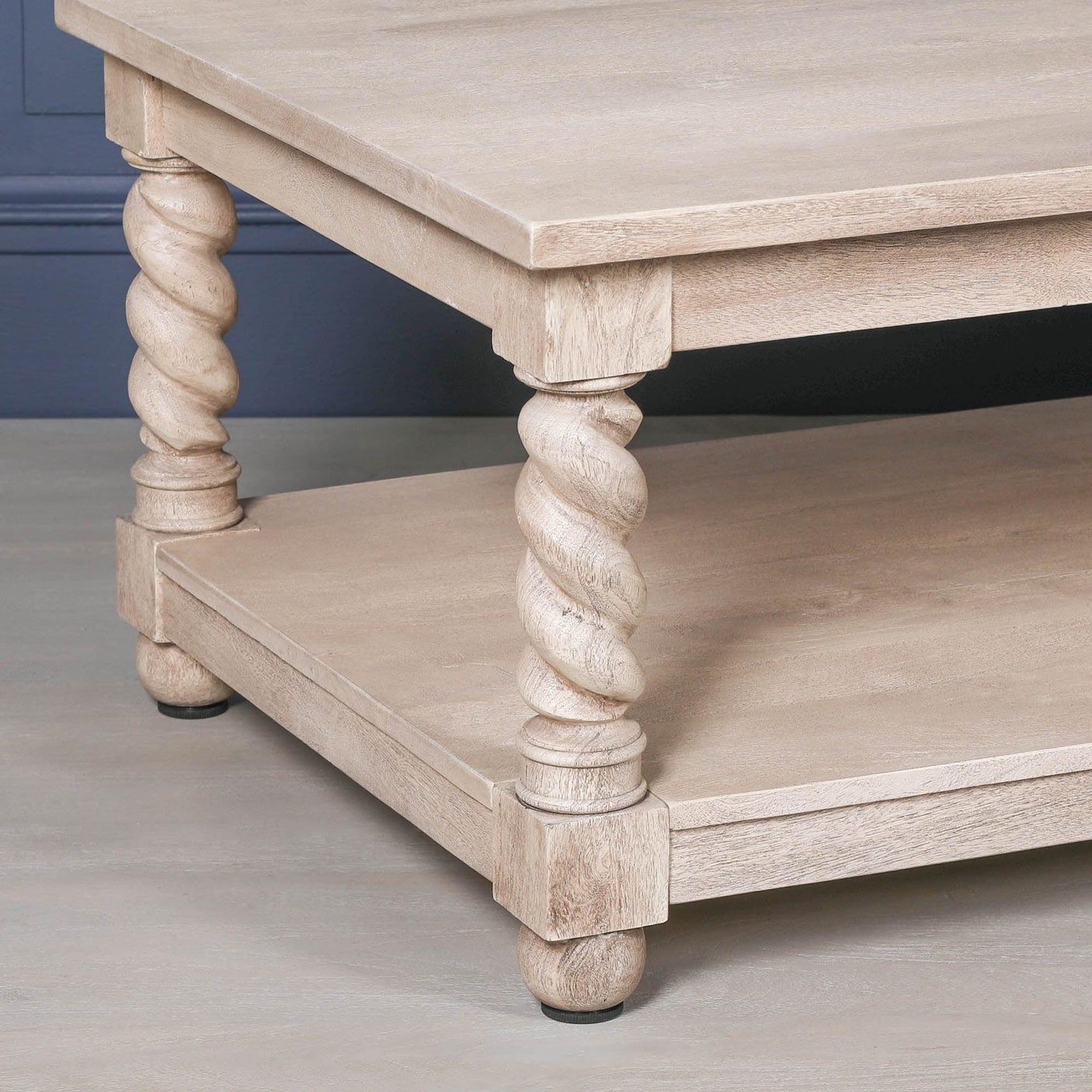 Oak coffee table with twisted carved legs and lower storage shelf, side angle view