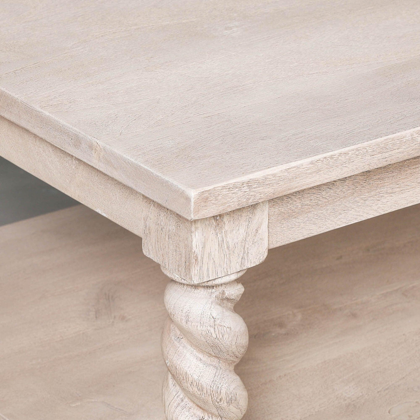 Light wood coffee table corner with carved spiral leg and smooth finish