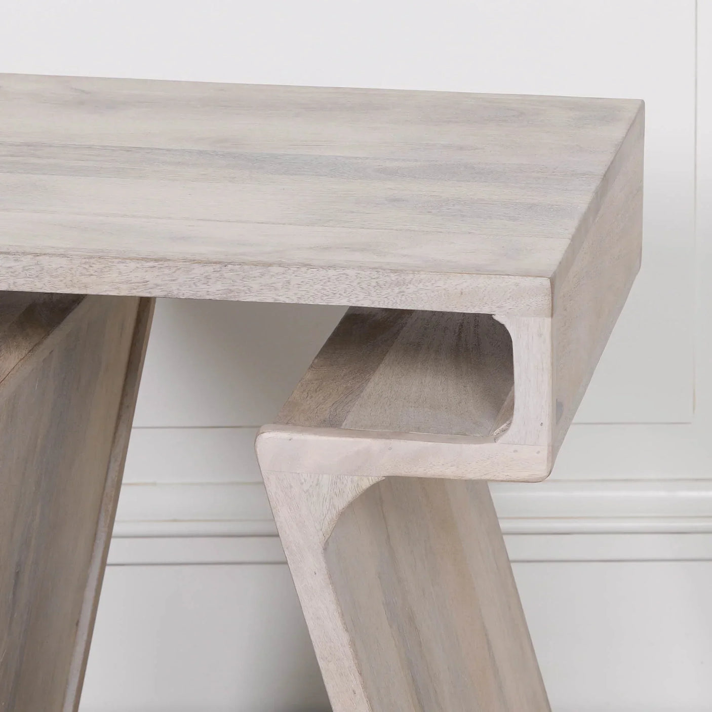 Light wood console table with modern angular design and natural grain finish closeup