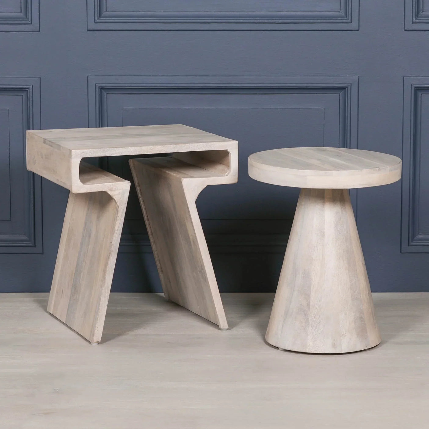 Light wood side table set with geometric modern design against dark wall