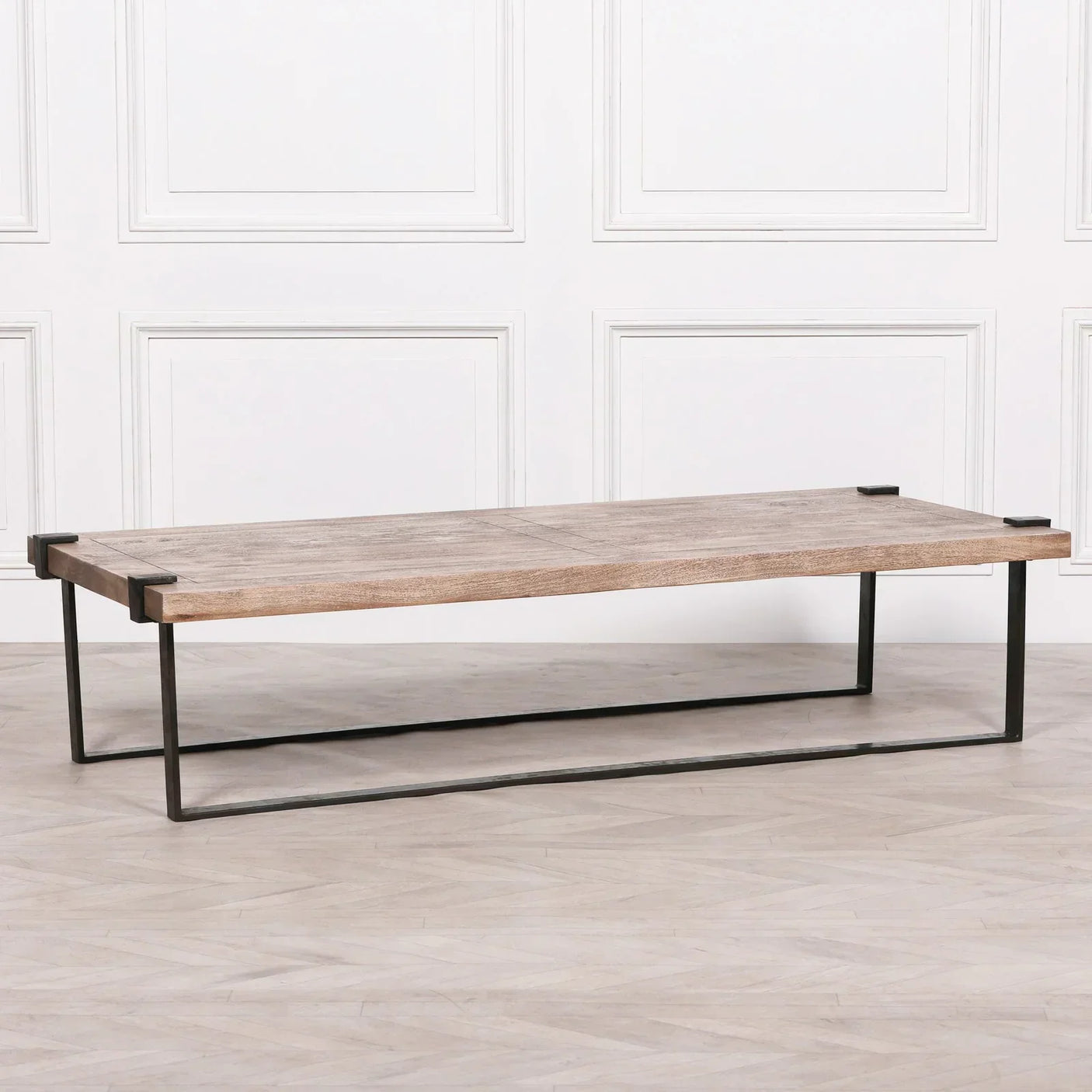 Rectangular wooden coffee table with black metal frame base on light wood flooring