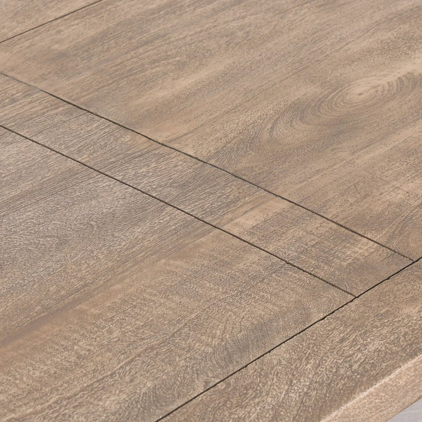 Closeup of rustic wood dining table surface showing grain and panel join design
