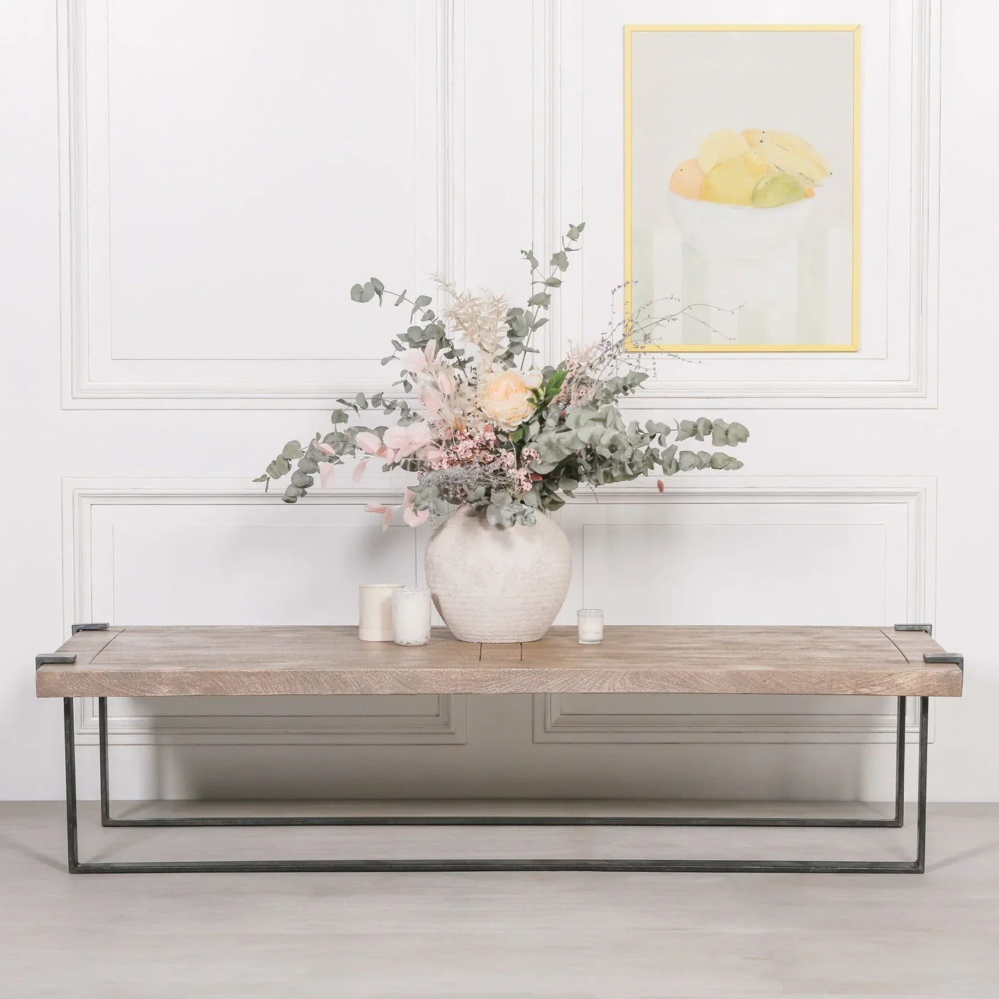 Wood and metal coffee table with decorative vase and candles in modern living room