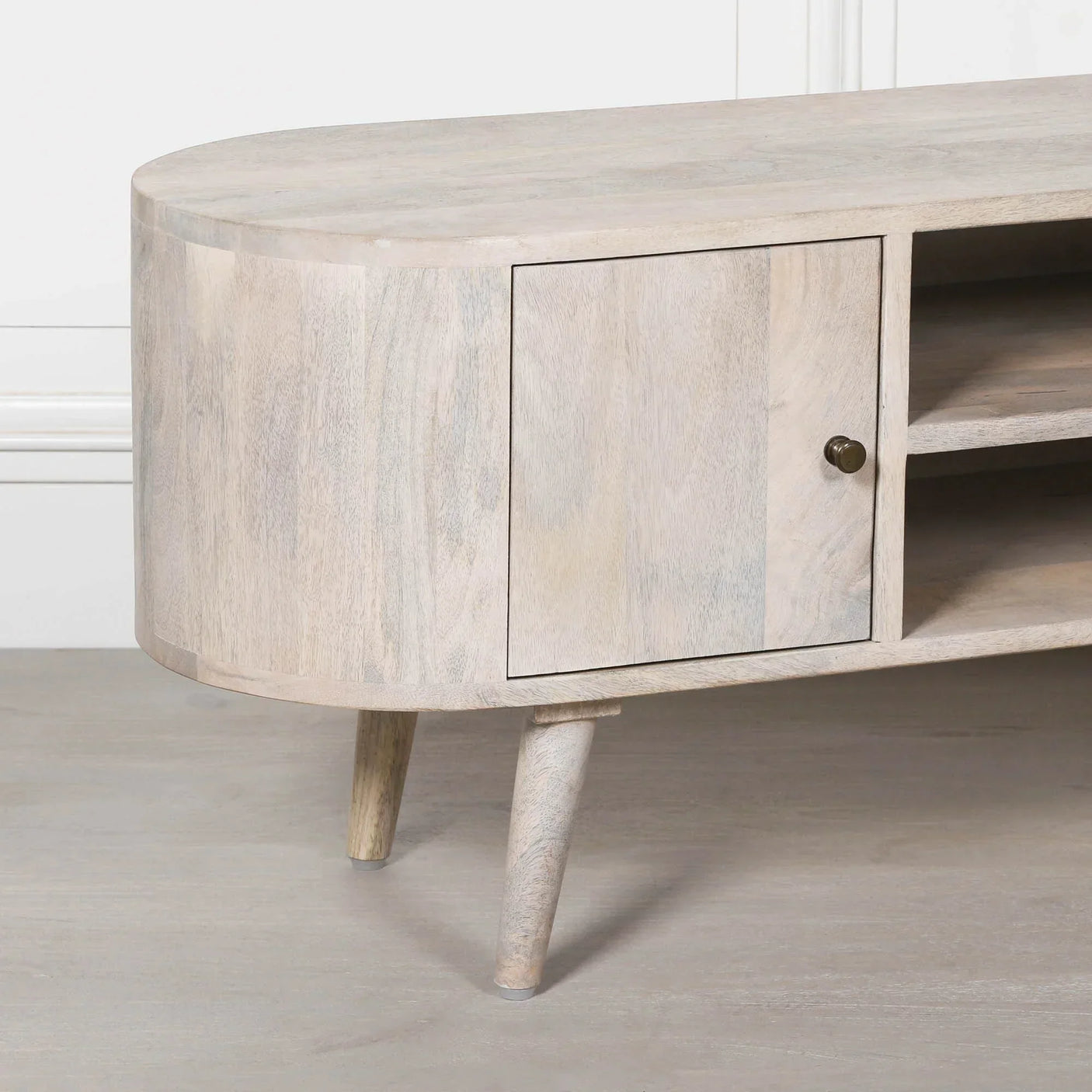Light wood TV unit with rounded edge, cabinet door and open shelf on angled legs