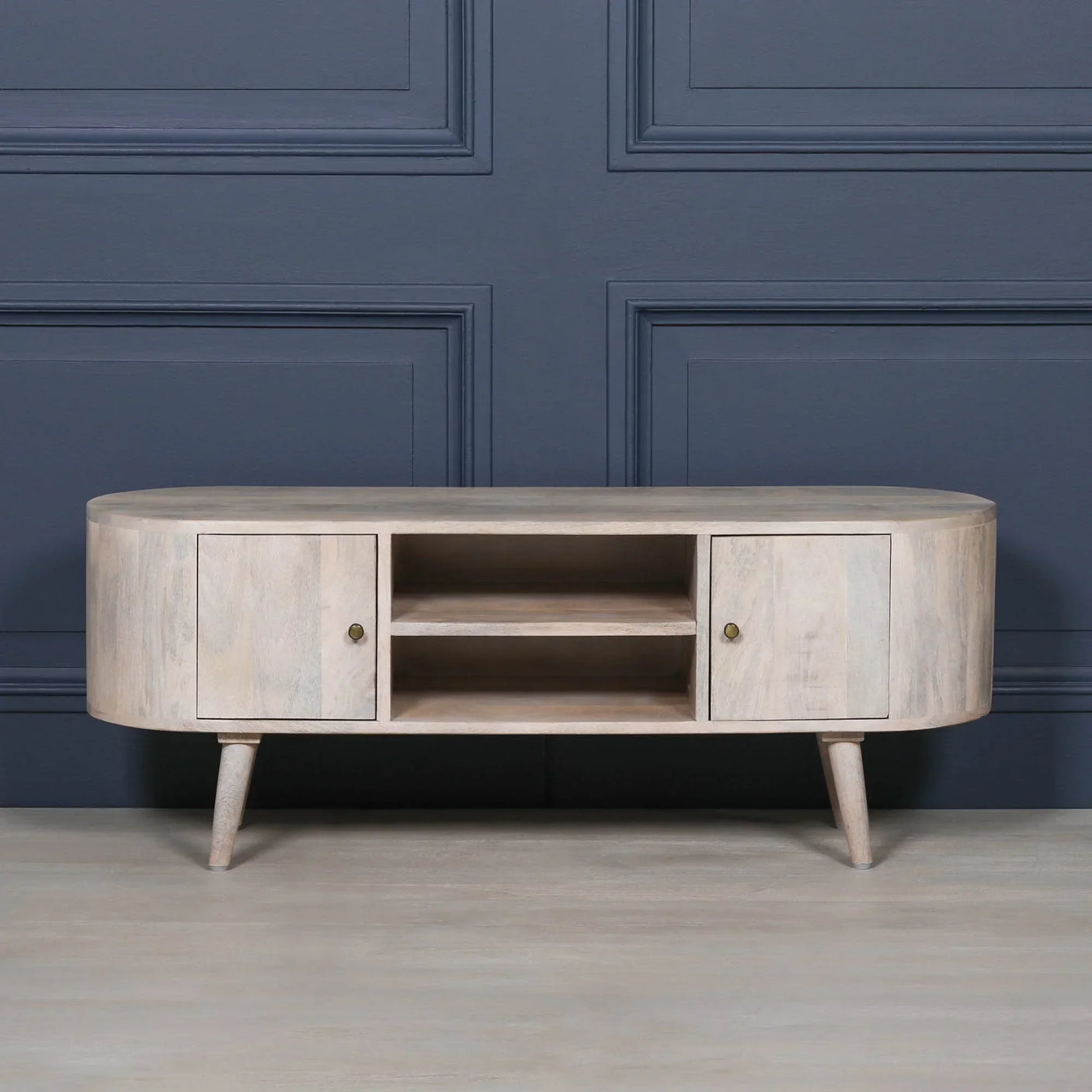 Light wood TV unit with rounded edges, two doors, open shelves, tapered legs