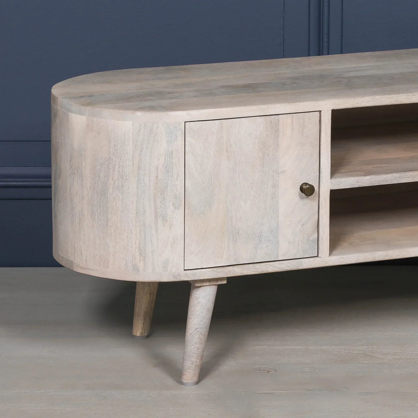 Light wood TV unit with rounded edge, cabinet door and open shelving, angled front view