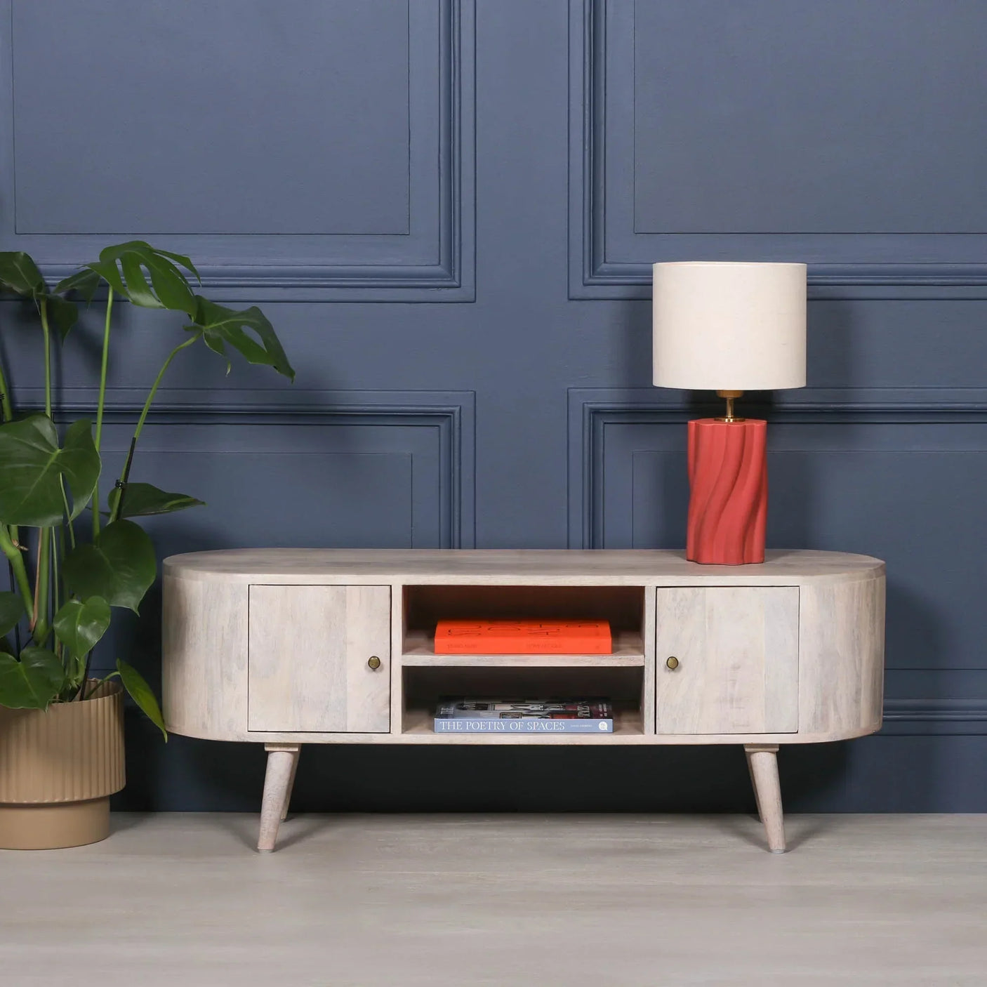 Light wood TV unit with storage shelves, closed cabinets, and a red lamp on top