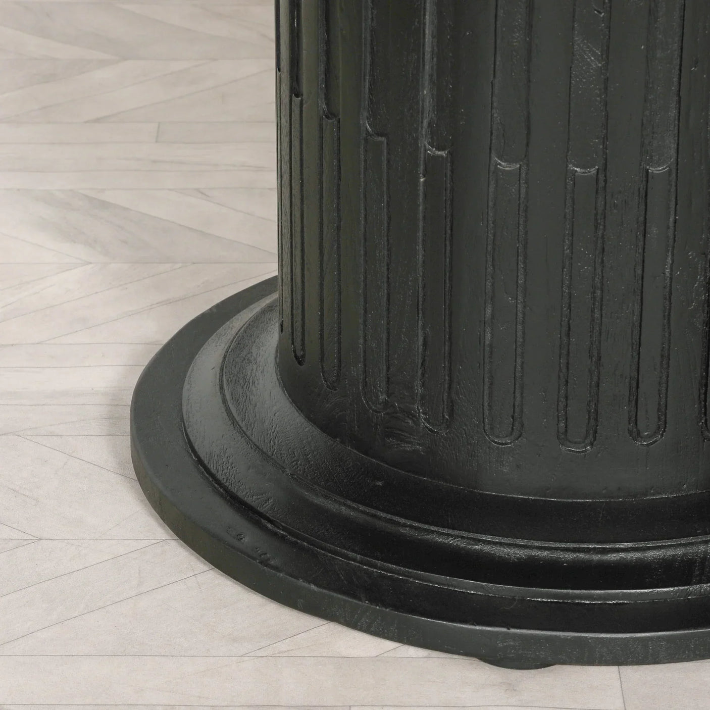 Black fluted dining table base on light wood floor
