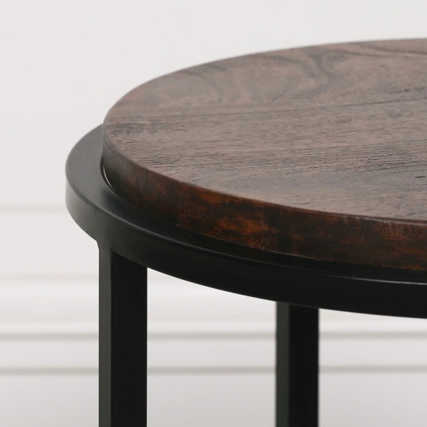 Round wooden side table with dark metal frame, close up of tabletop and legs