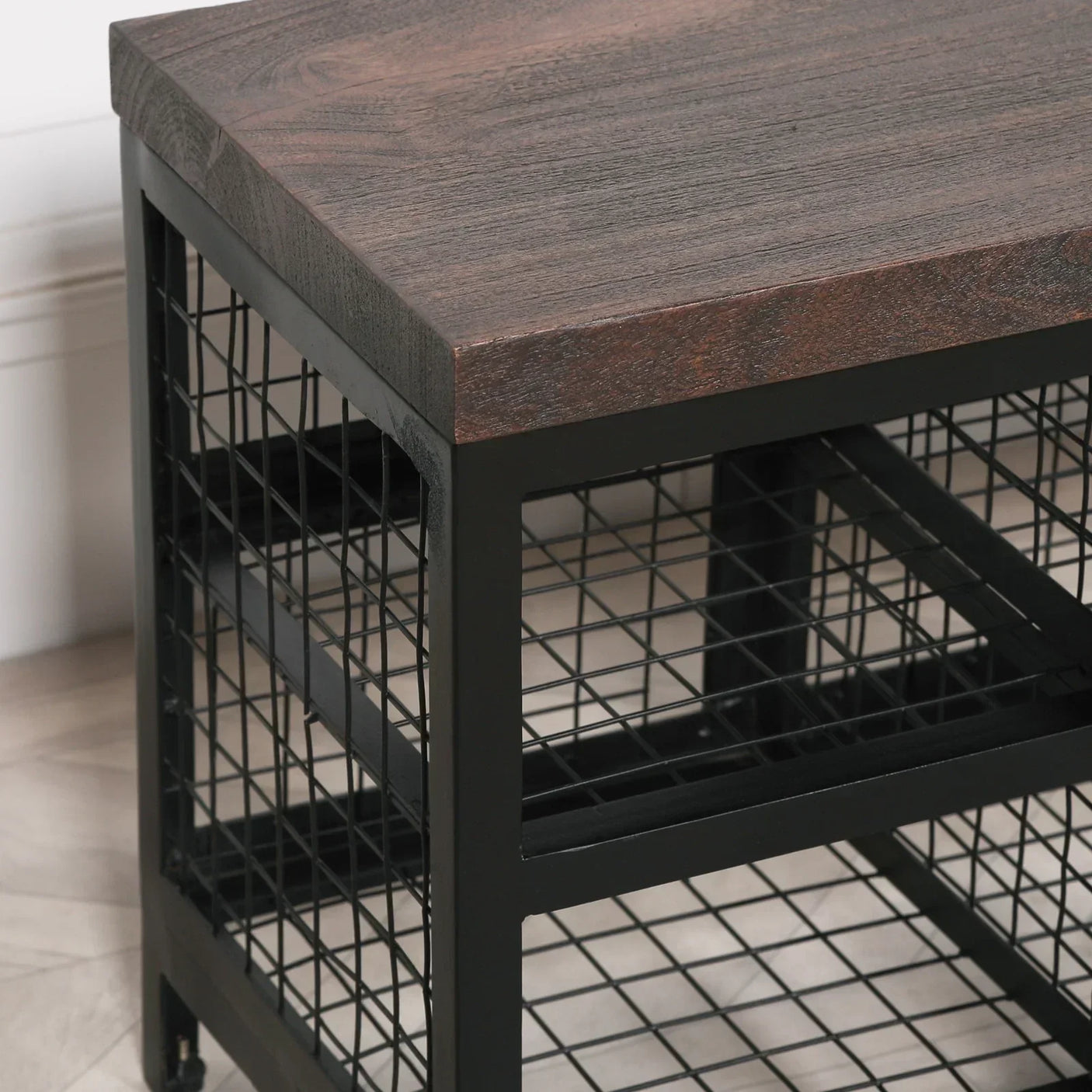 Industrial coffee table with dark wood top and black metal grid frame corner view