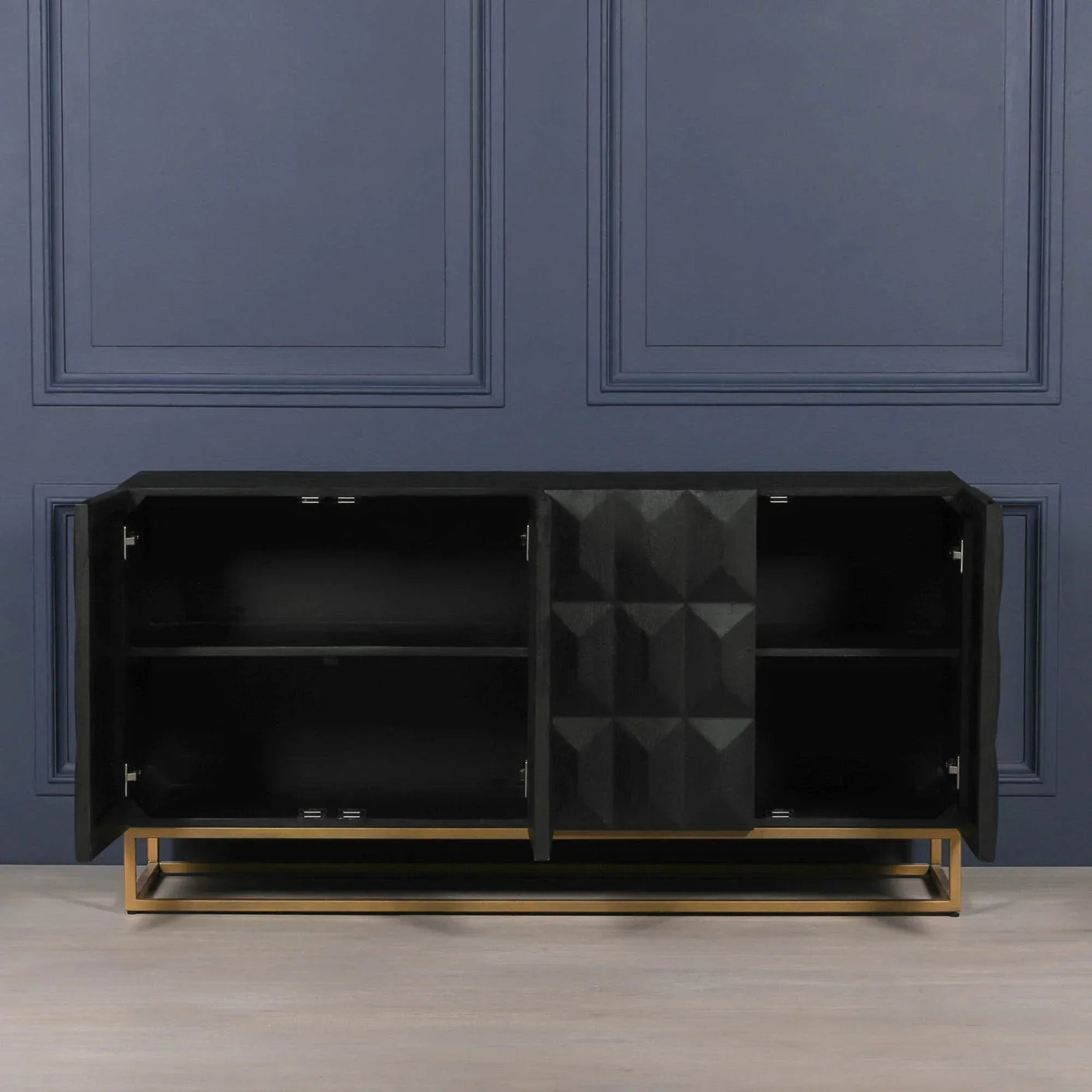 Black sideboard with geometric doors and gold metal base, open to reveal storage shelves