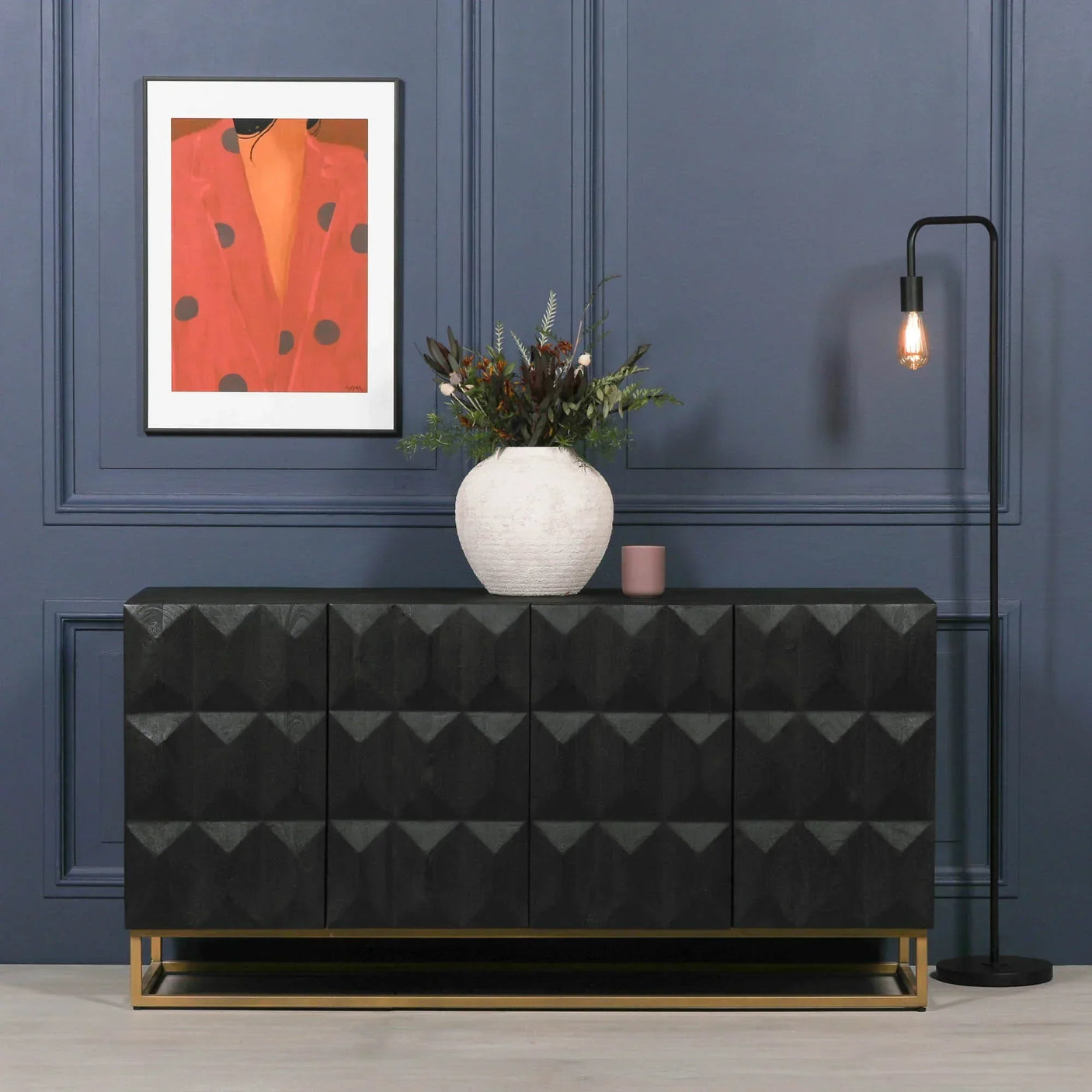 Black geometric sideboard with gold base, white vase, and modern floor lamp in blue room