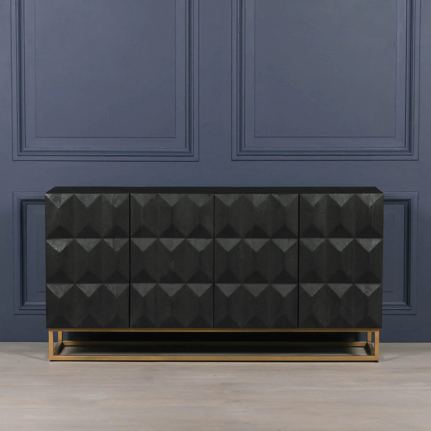 Black geometric sideboard with gold metal base against blue wall and light wood floor