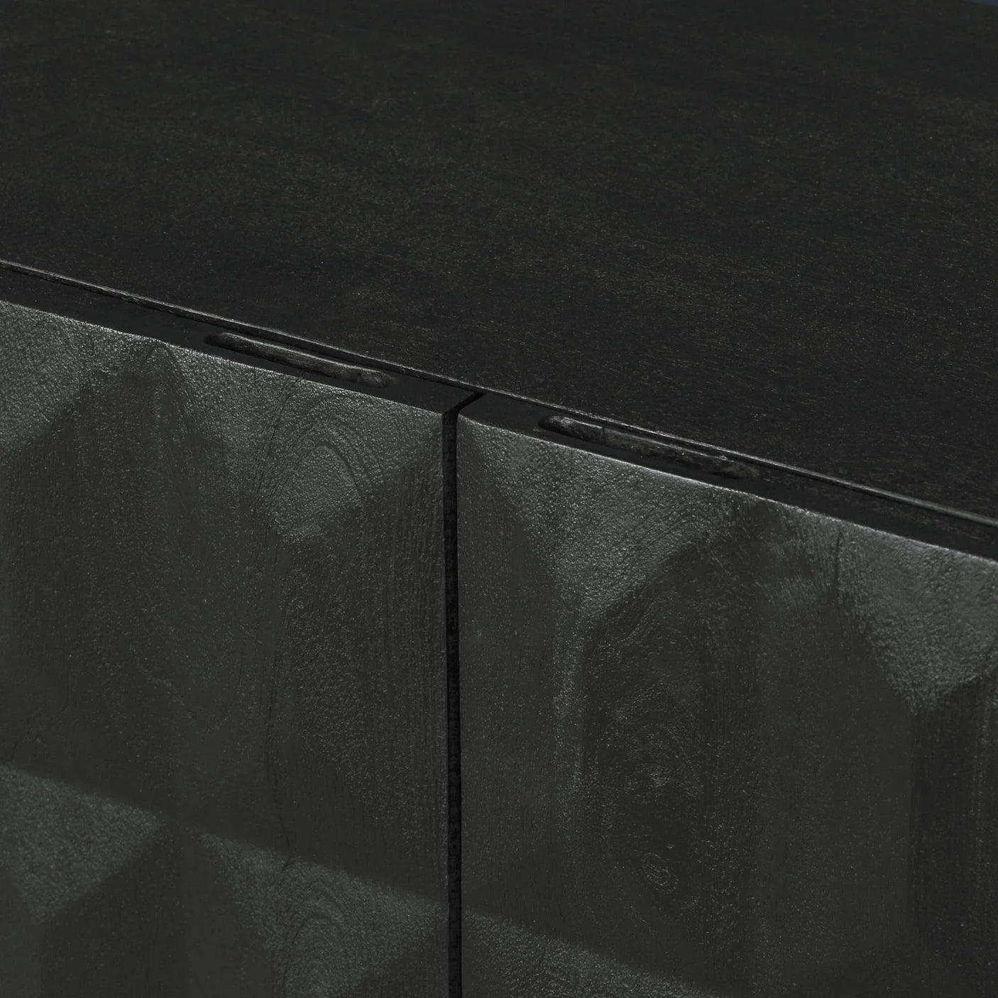 Closeup of black wood cabinet with textured geometric door pattern