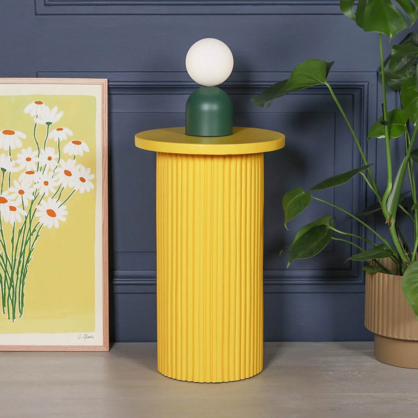 Yellow ribbed side table with round top, green and white lamp, modern interior decor
