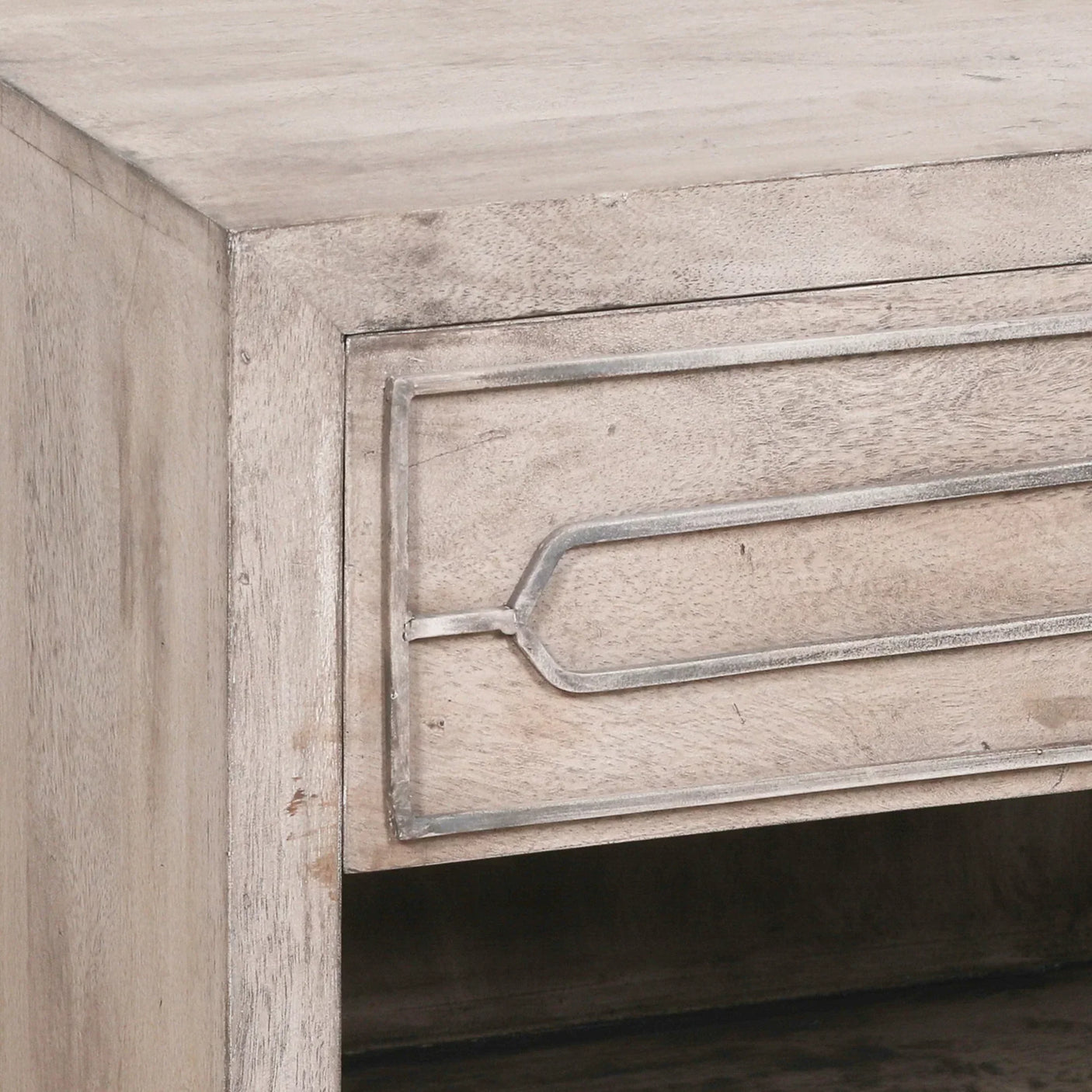 Light wood bedside table corner showing drawer with metal trim detail