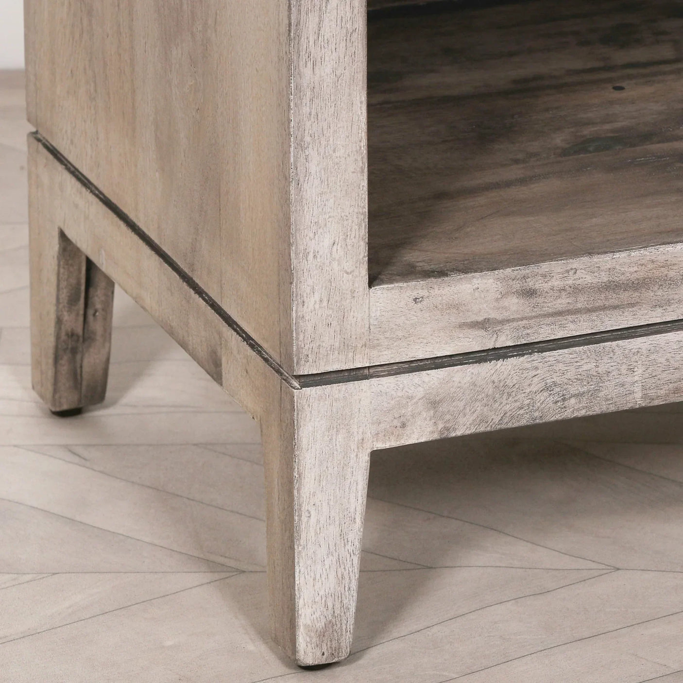 Light wood furniture leg and corner with natural grain, angled on tiled floor