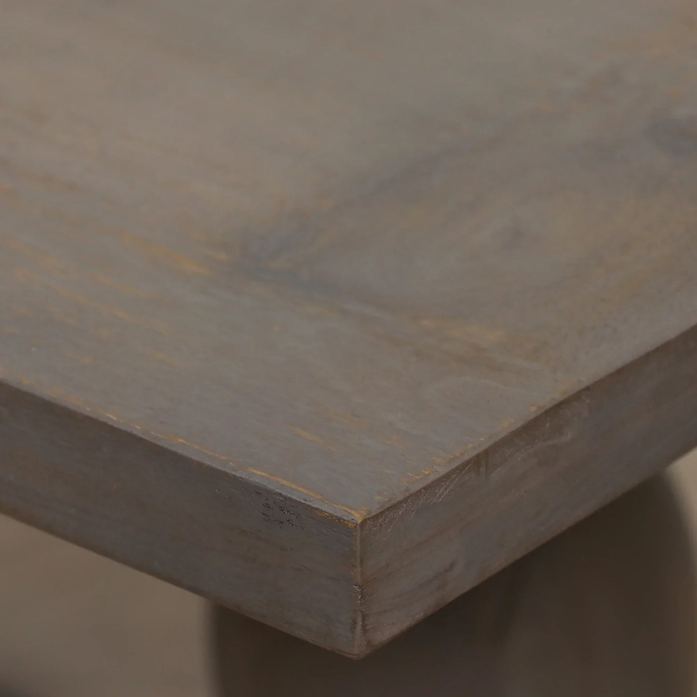 Close-up of wooden dining table corner with natural grain and matte brown finish