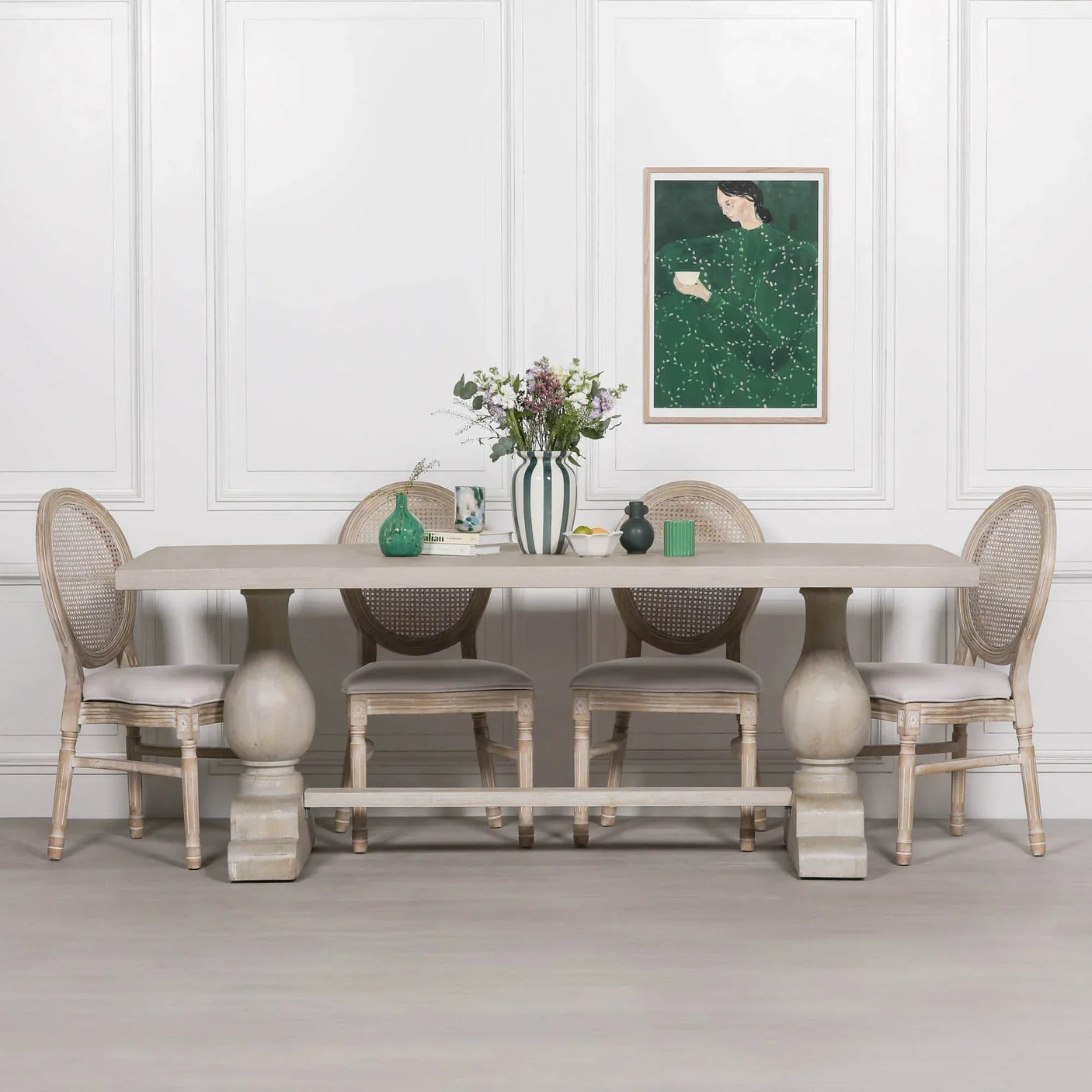 Rectangular wooden dining table with four rattan back chairs in light neutral finish