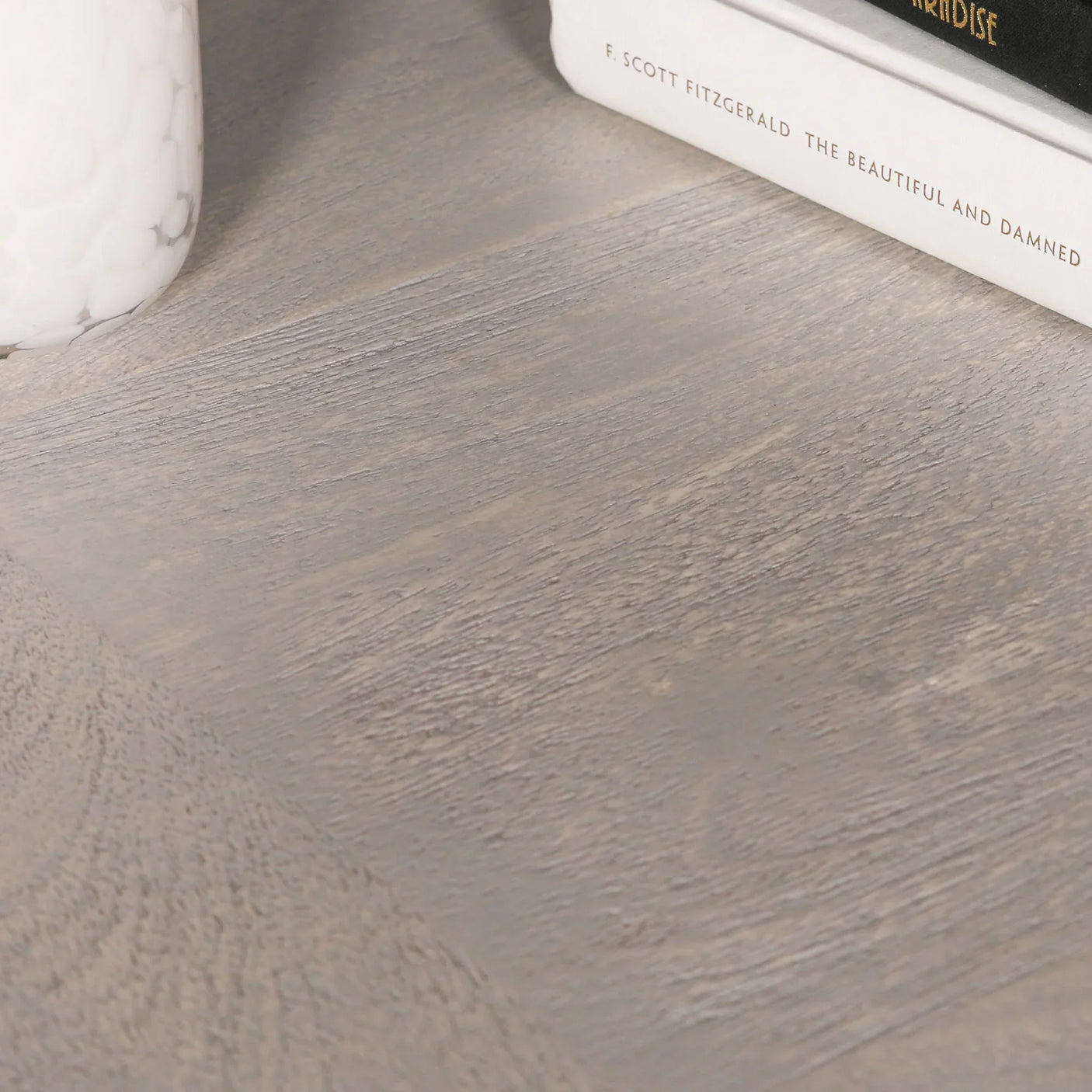 Closeup of grey oak dining table surface with wood grain texture and decor details
