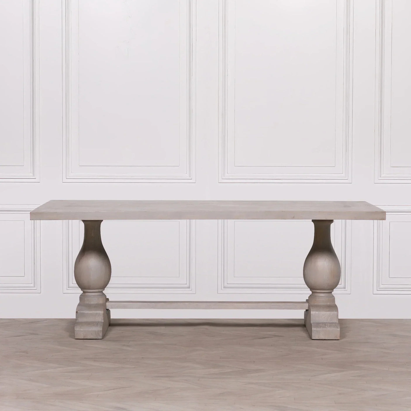 Rectangular wooden dining table with turned pedestal legs and light finish