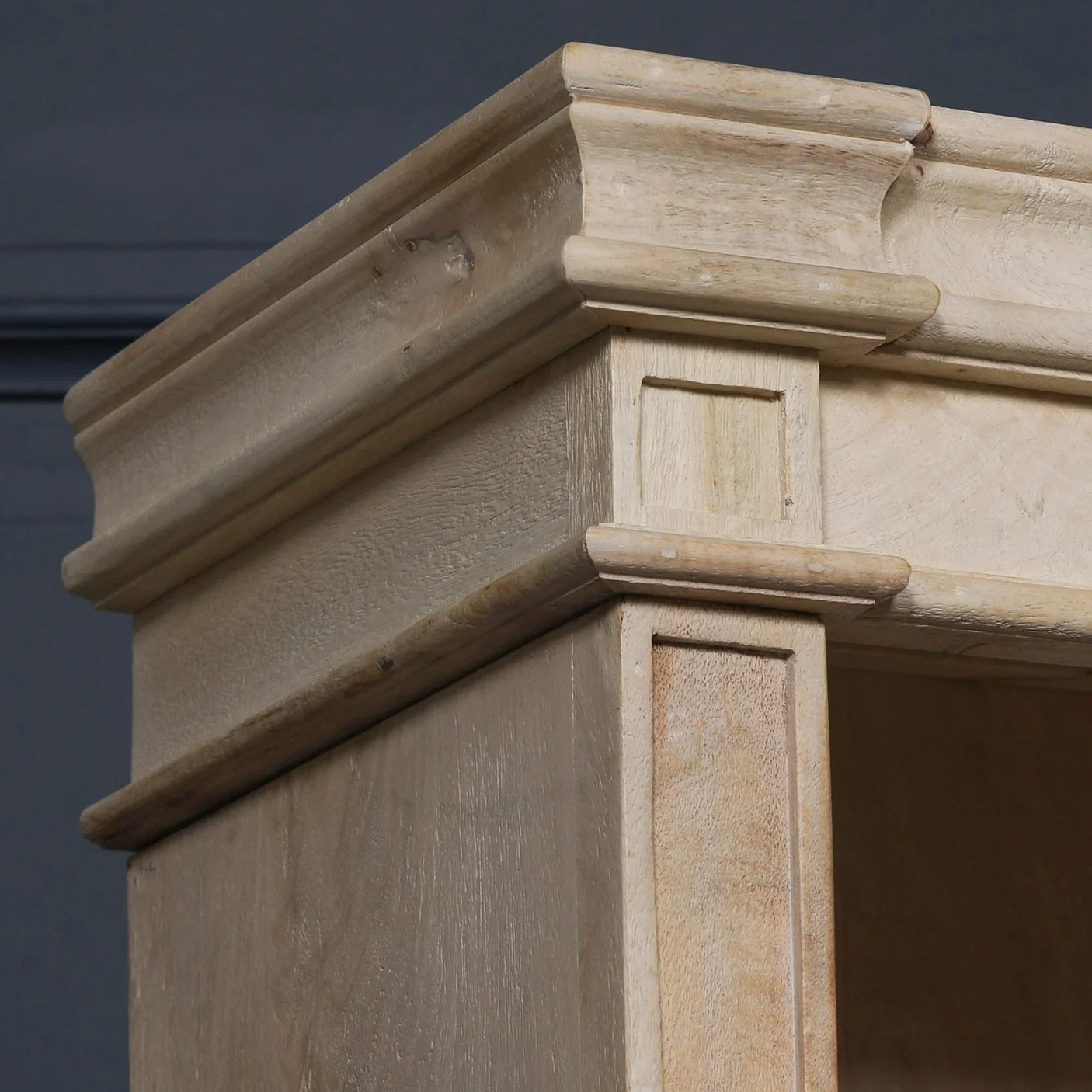 Corner detail of solid wood cabinet with natural finish and classic molding