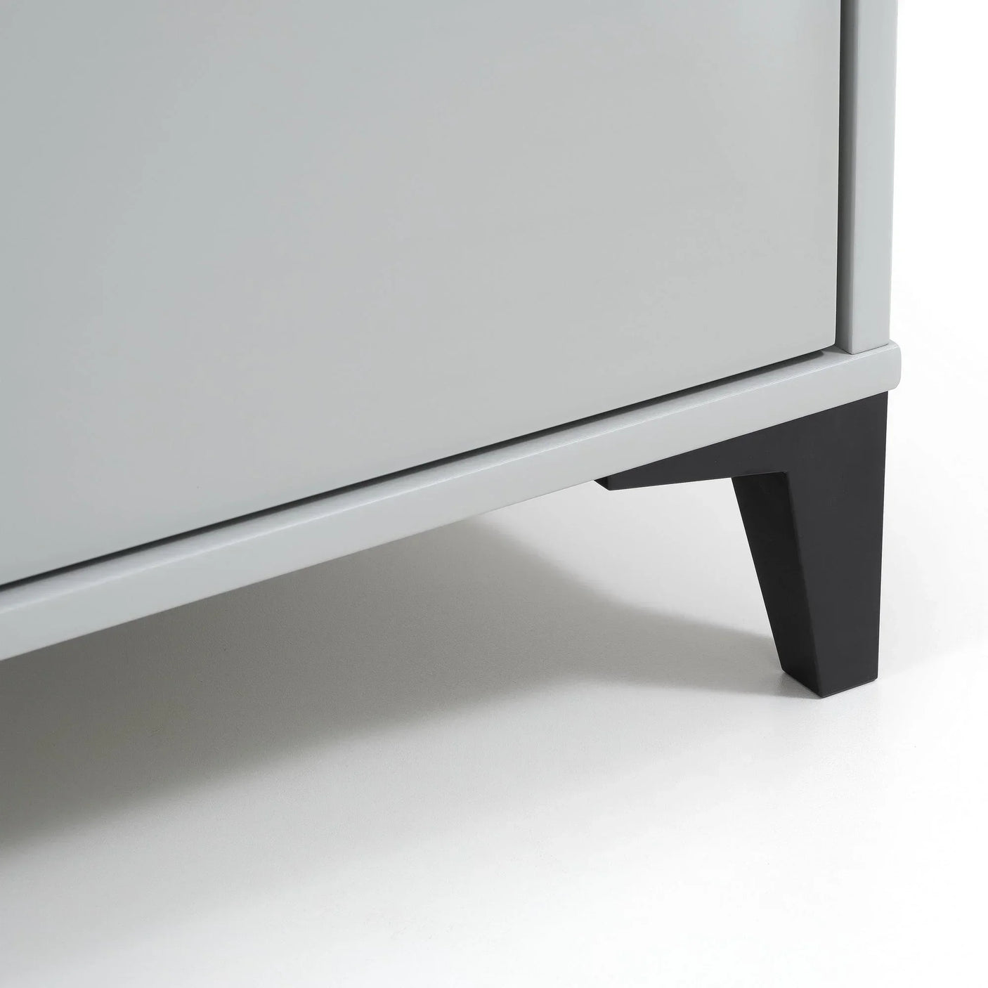 Grey wooden desk corner with black angled leg on white background