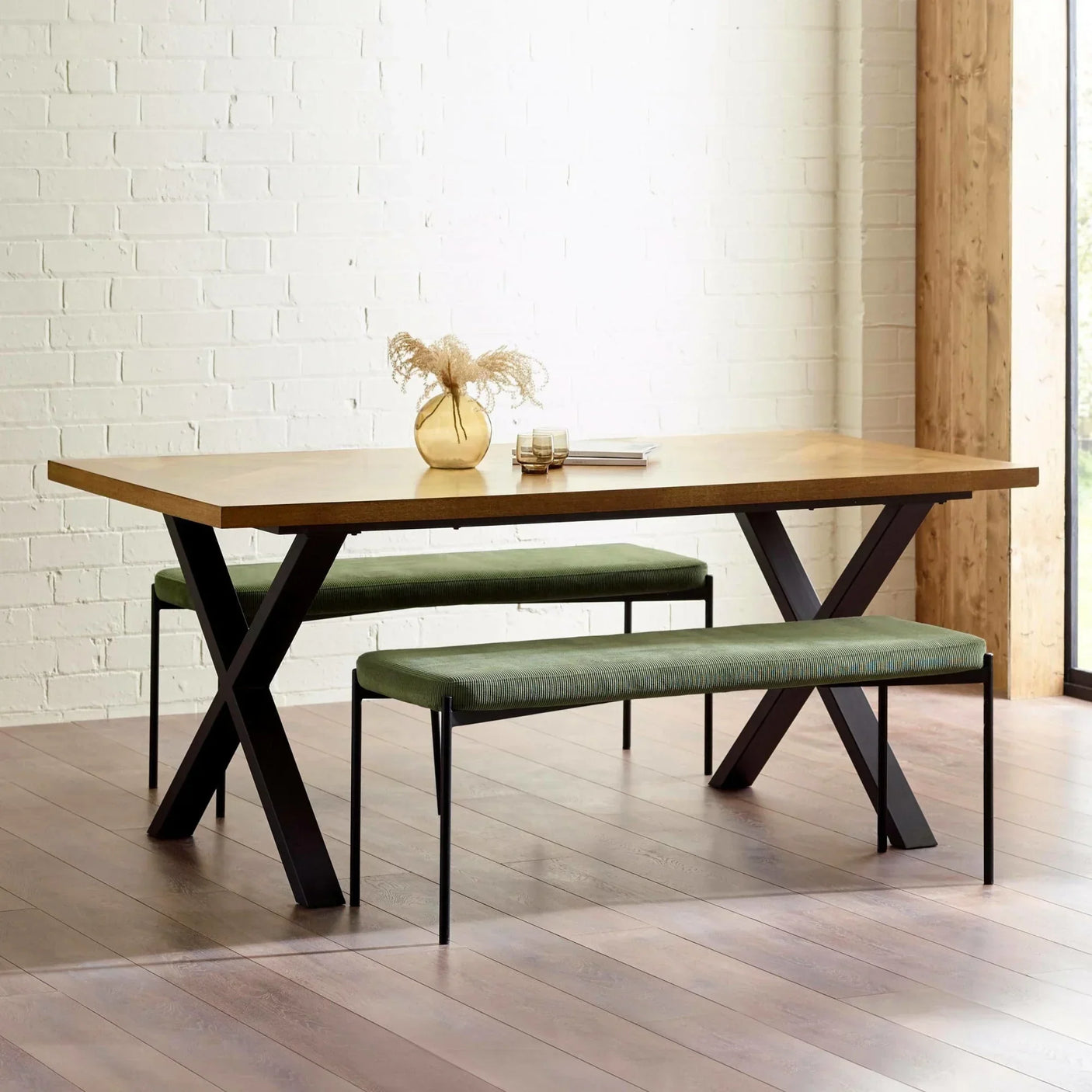 Rectangular wooden dining table with black metal legs and two green fabric benches
