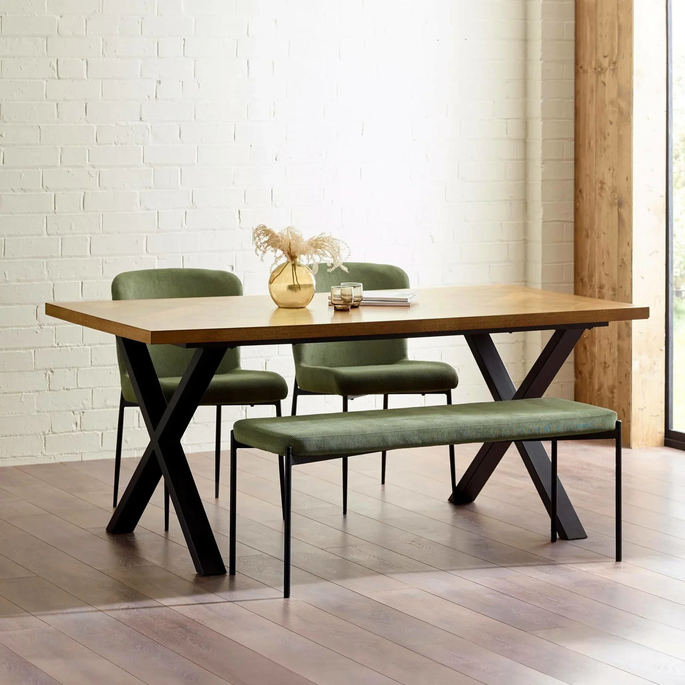 Oak dining table with black legs, green upholstered bench and chairs in modern dining room