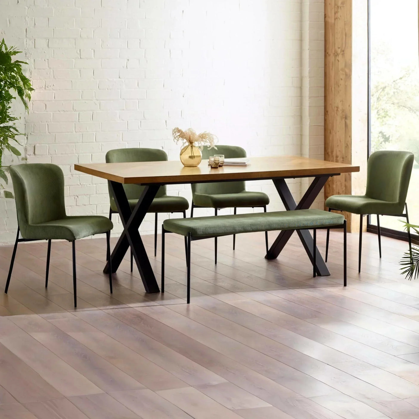 Oak dining table with black metal legs, green upholstered chairs and bench in bright room