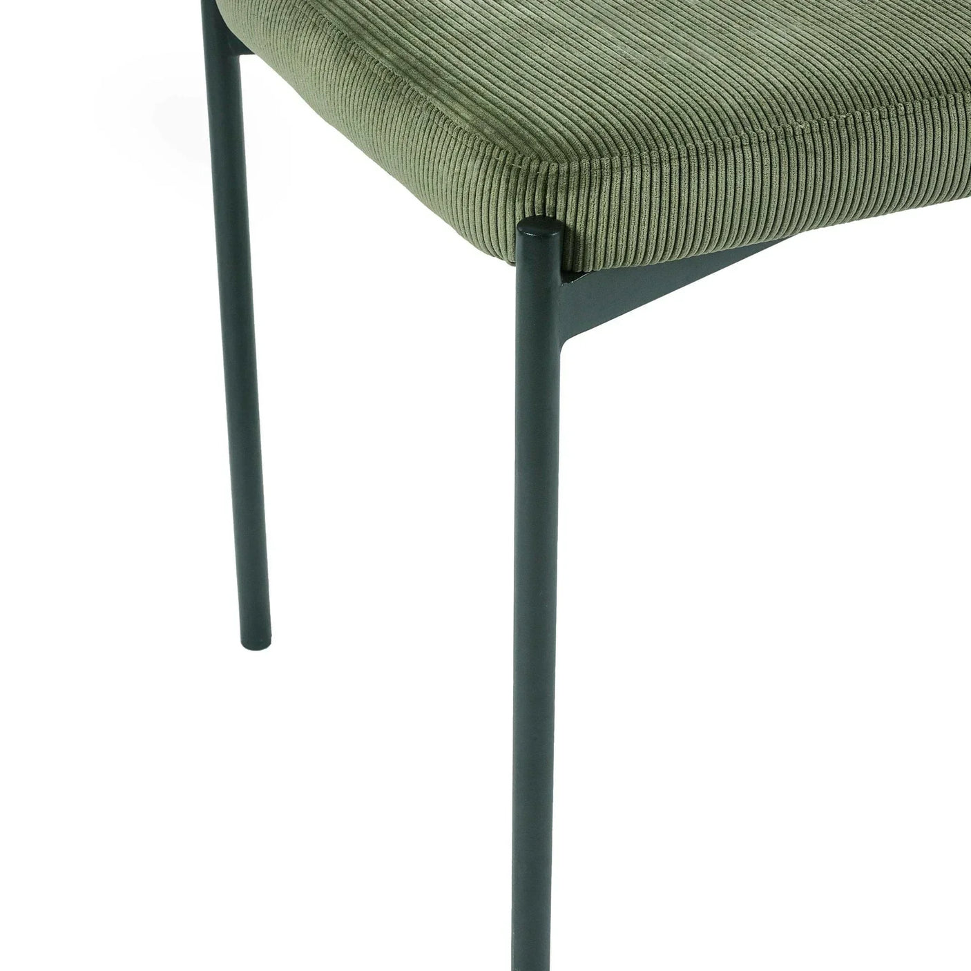 Green corduroy dining chair seat with slim black metal legs, close-up view