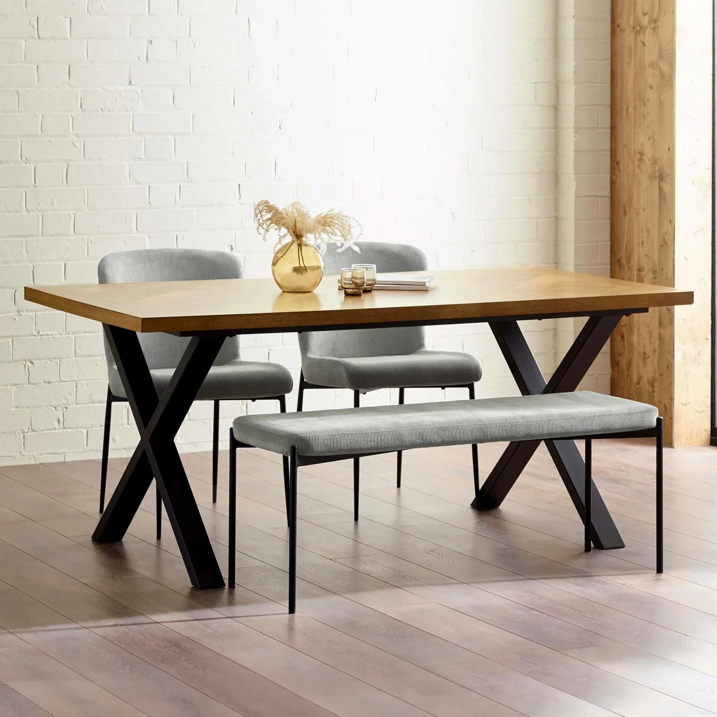 Rectangular wooden dining table with black metal legs, grey bench and chairs in modern room