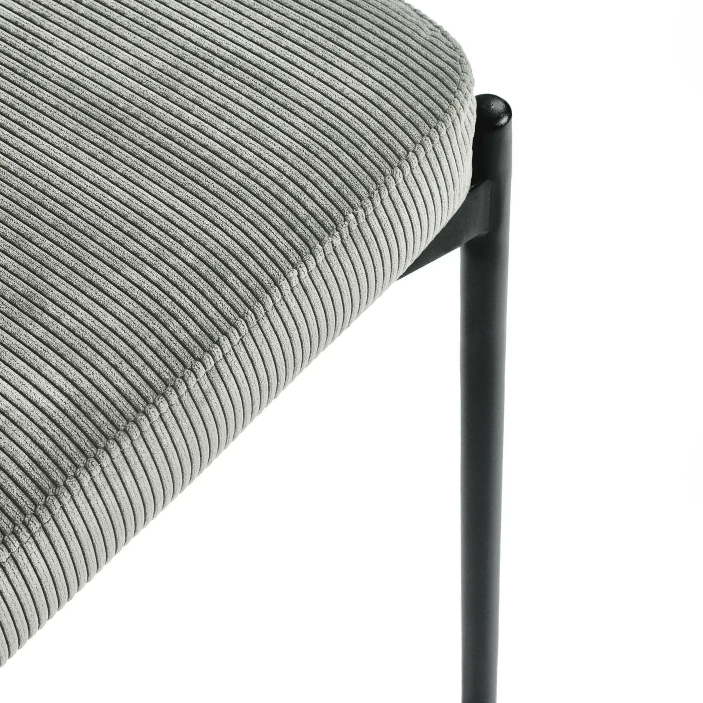 Close-up of grey corduroy dining chair seat with black metal leg