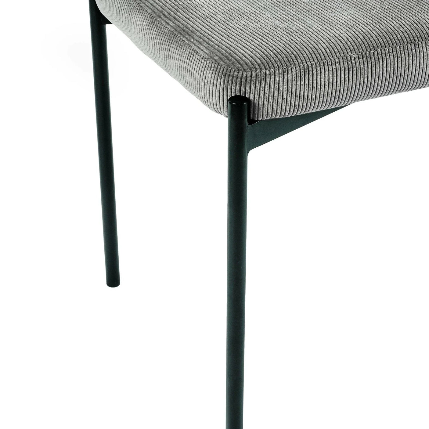 Close view of grey upholstered dining chair with black metal legs