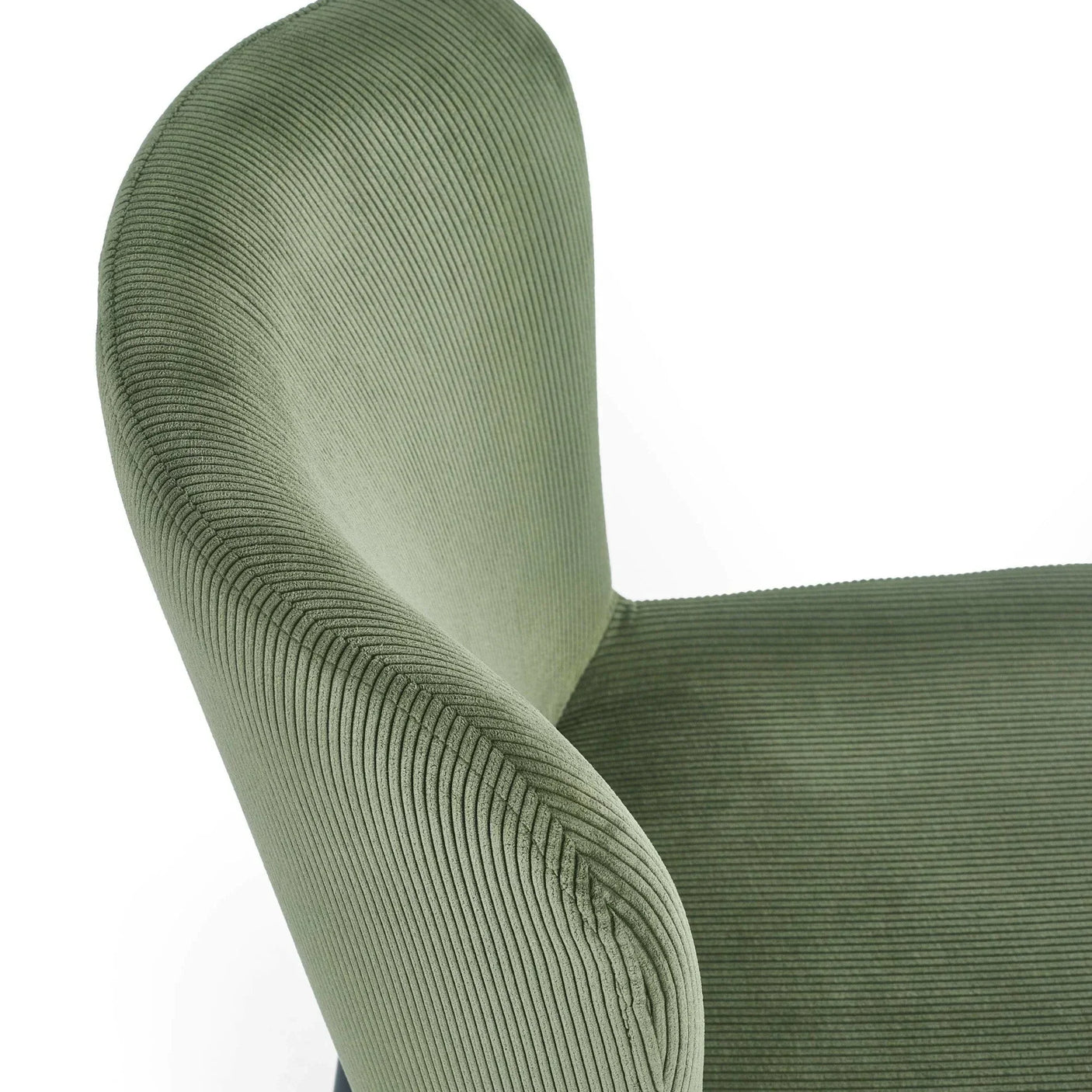 Green corduroy armchair with curved backrest, close-up of seat and upholstery texture