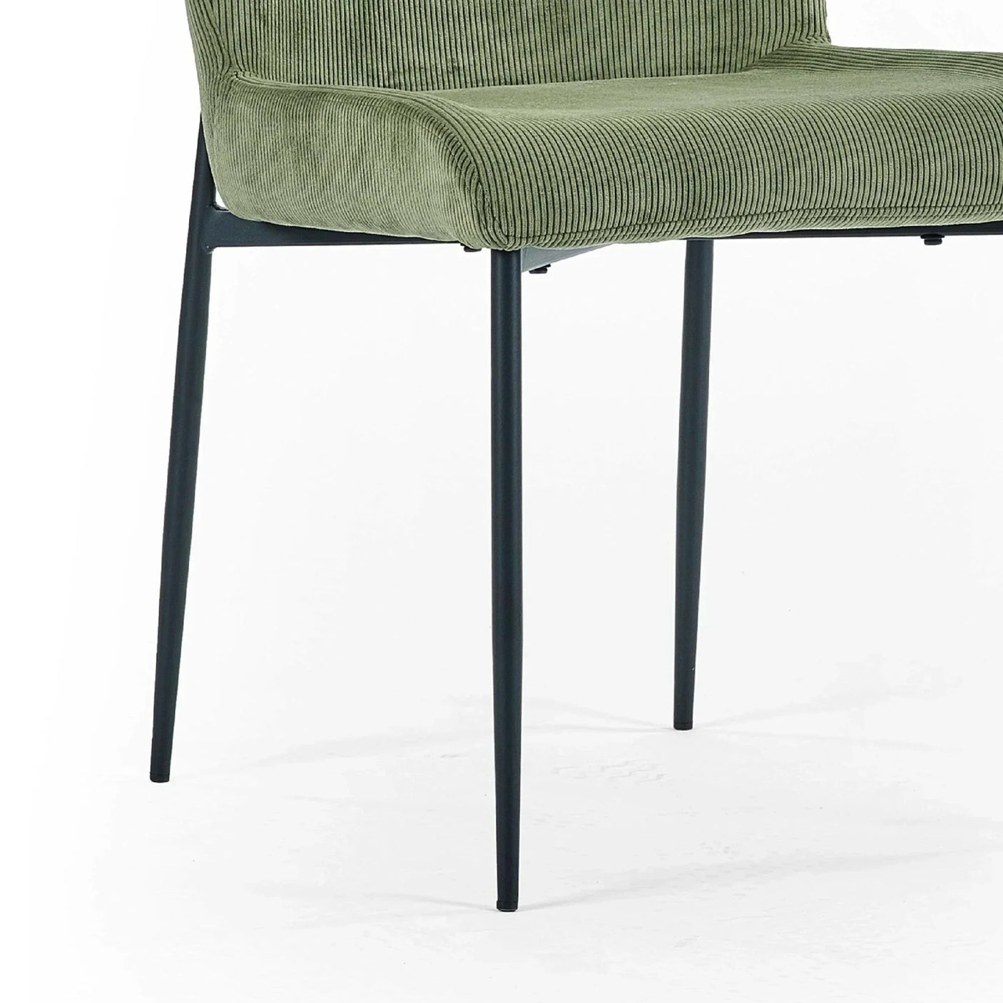 Green corduroy dining chair with black metal legs, side angle focus on seat and structure