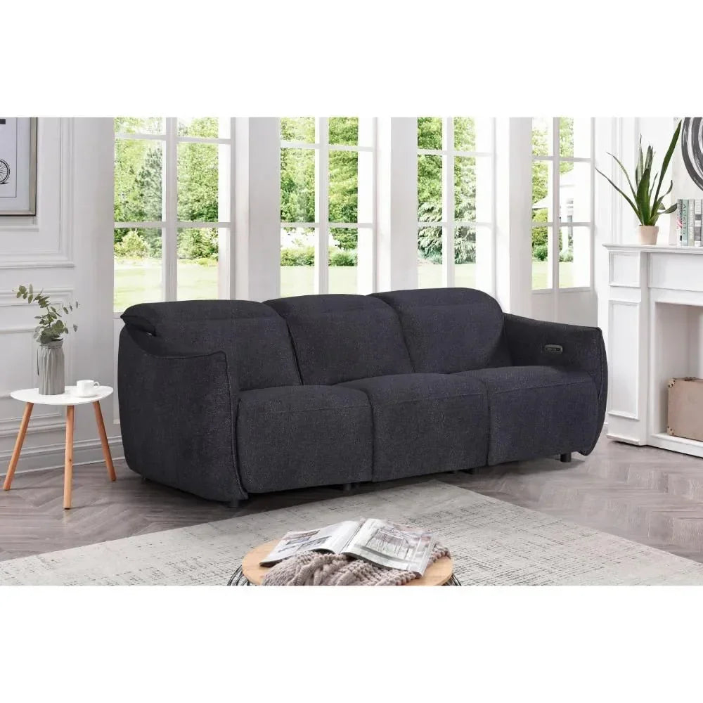 Dark grey fabric sofa with three seats positioned in a bright living room by large windows